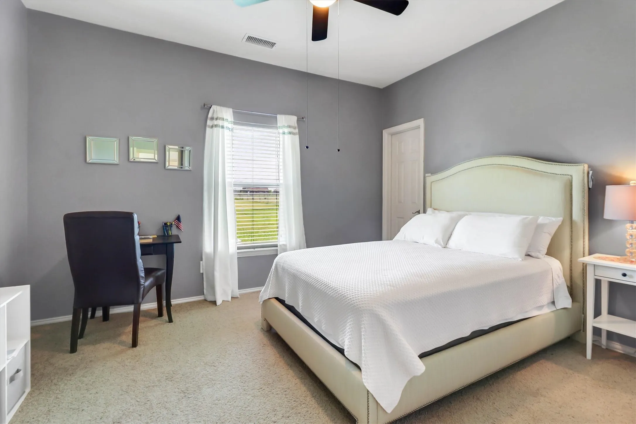 Bedroom with light gray walls and neutral carpeting
