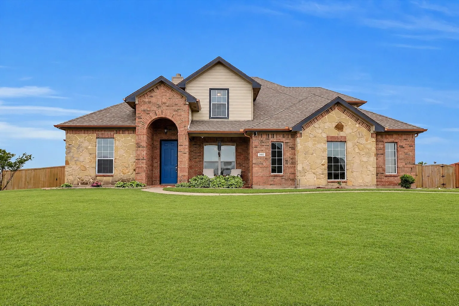 Expansive front yard with a deep green lawn