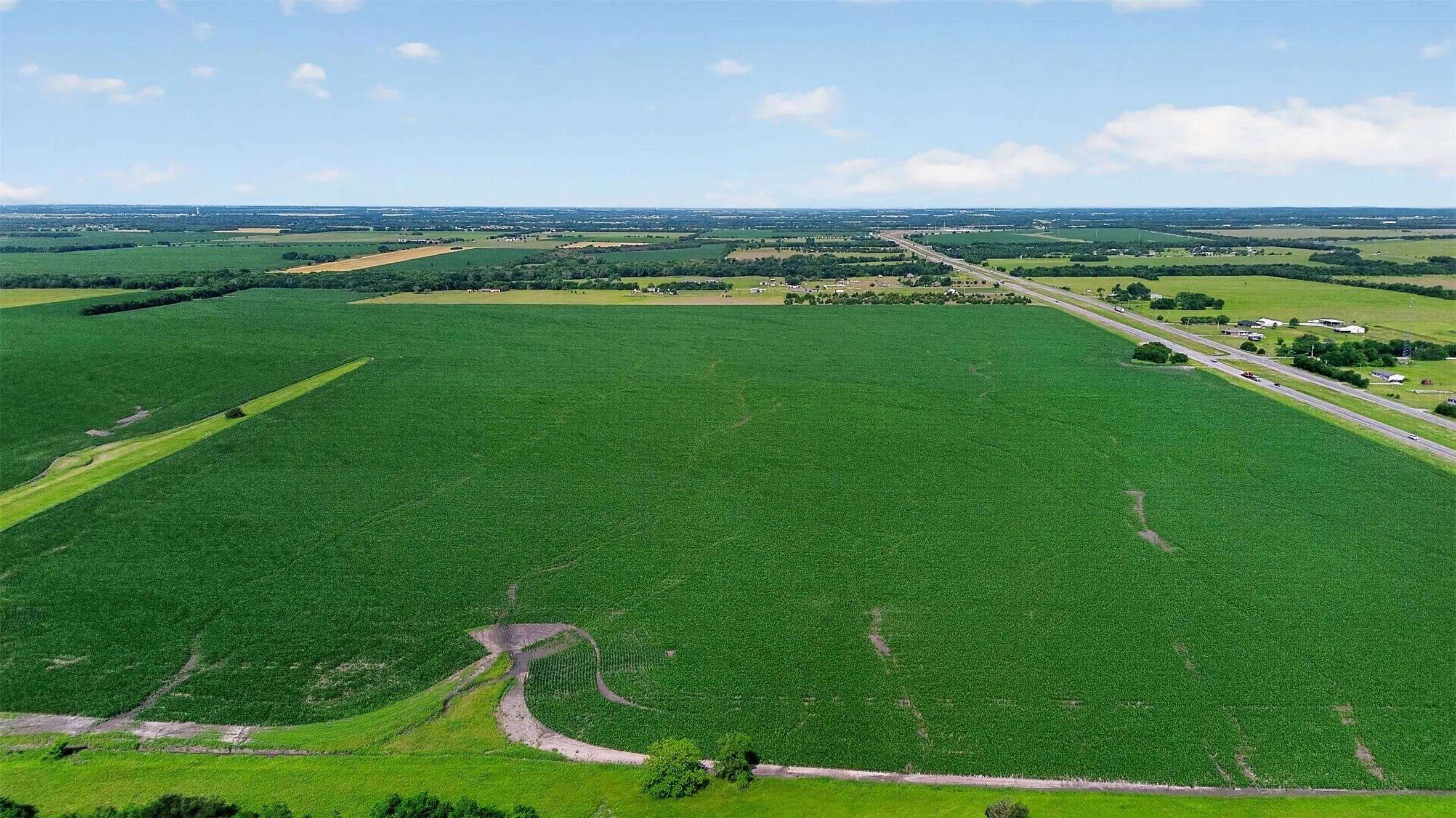 Expansive agricultural land featuring a verdant crop field