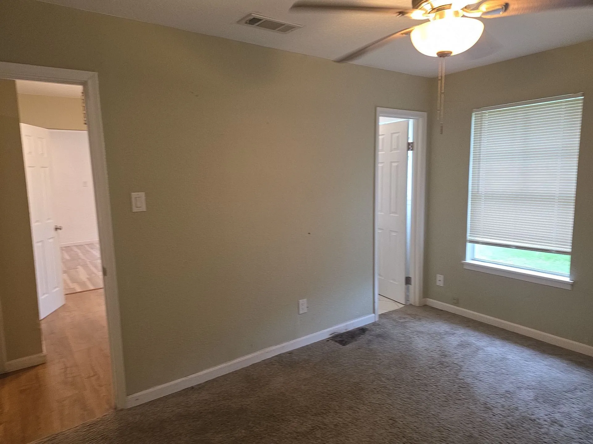 Neutral-toned walls complement the textured carpeting