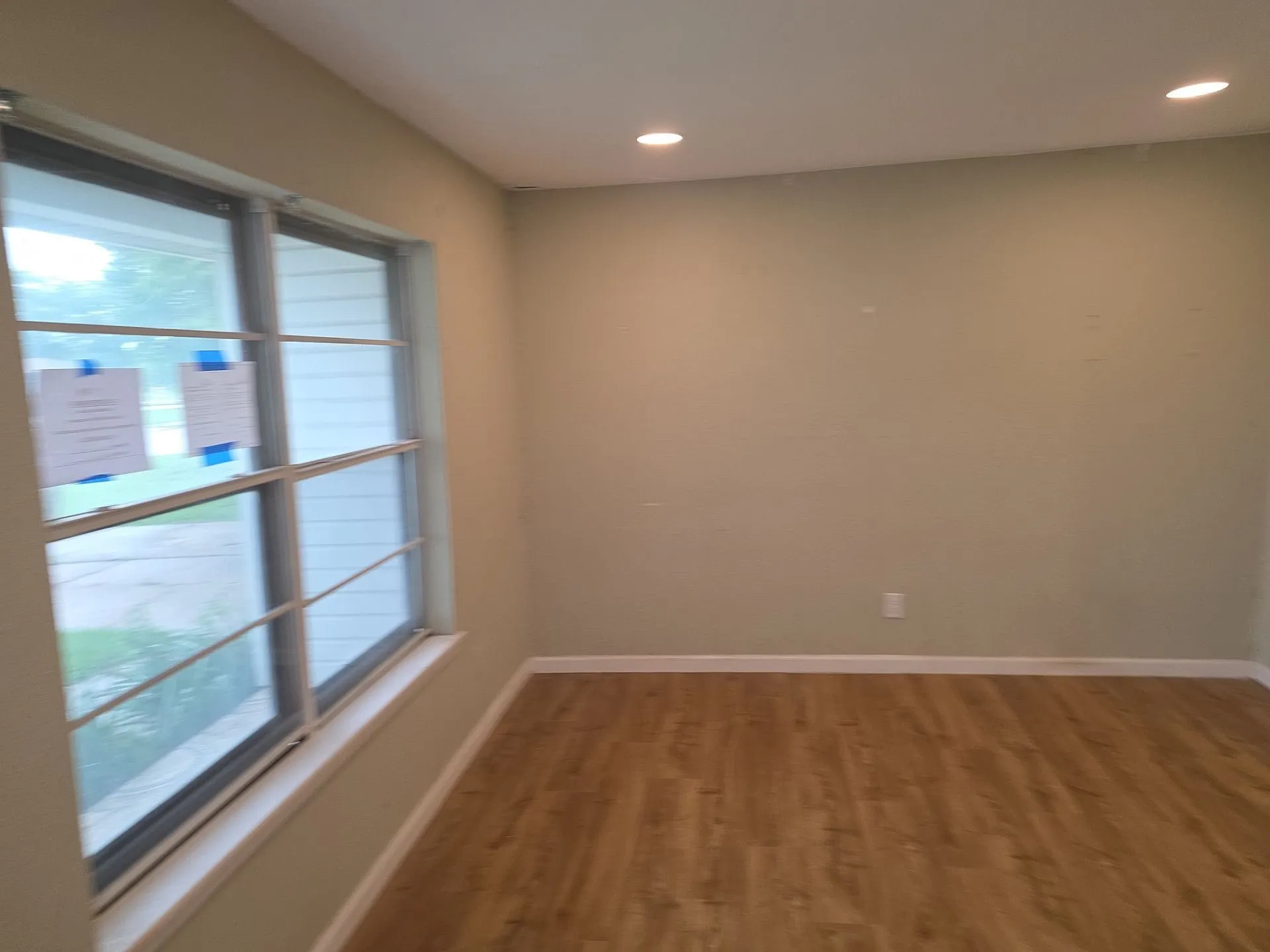 Living area featuring wood-finish flooring, recessed lighting, and a large multi-pane window