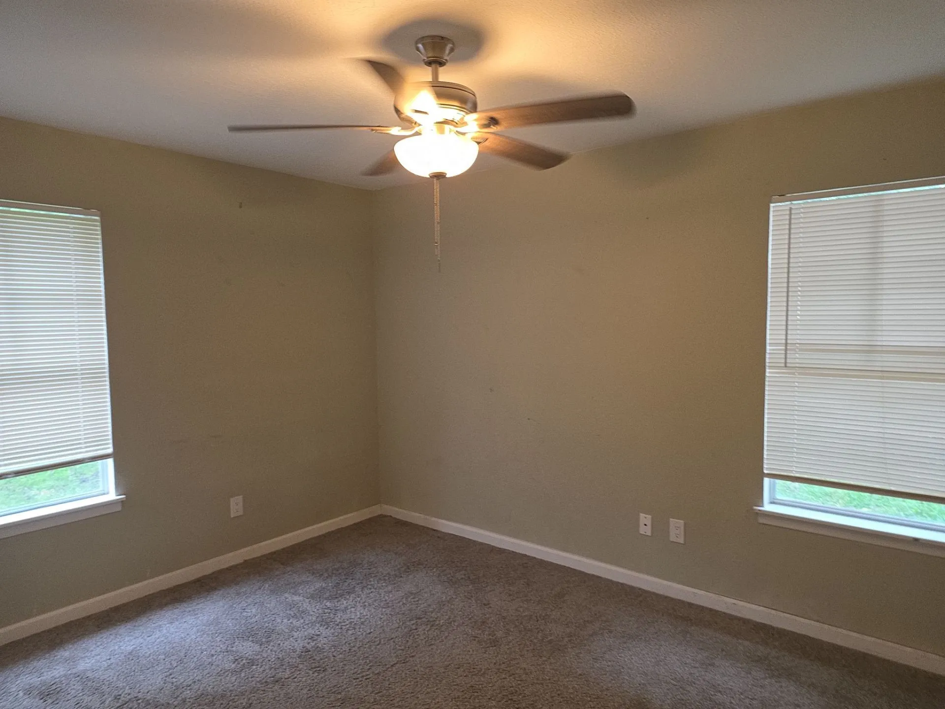 Carpeted room featuring a ceiling fan with integrated lighting