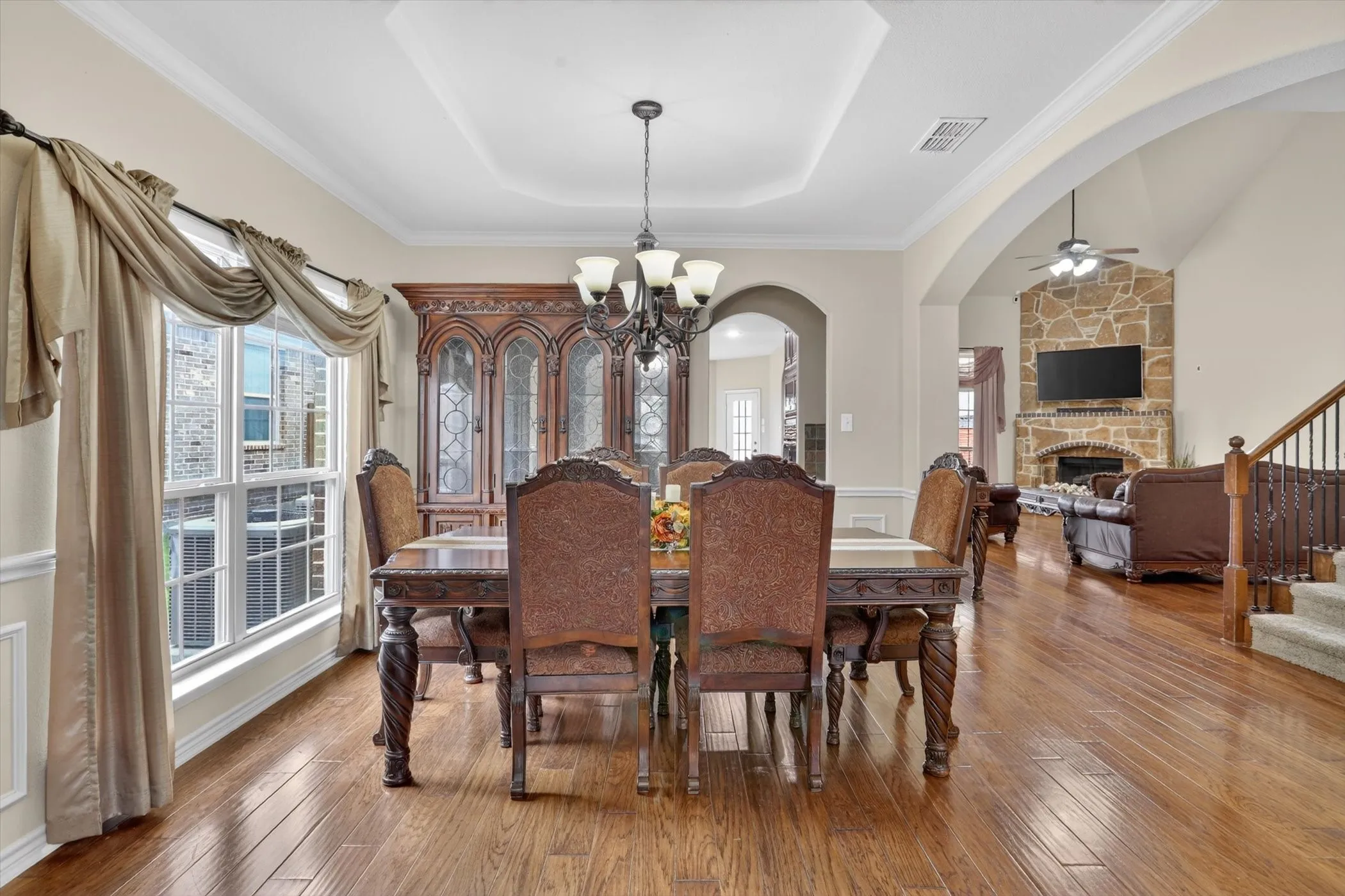 Formal dining area featuring rich wood-finish flooring, a coffered ceiling, and crown molding