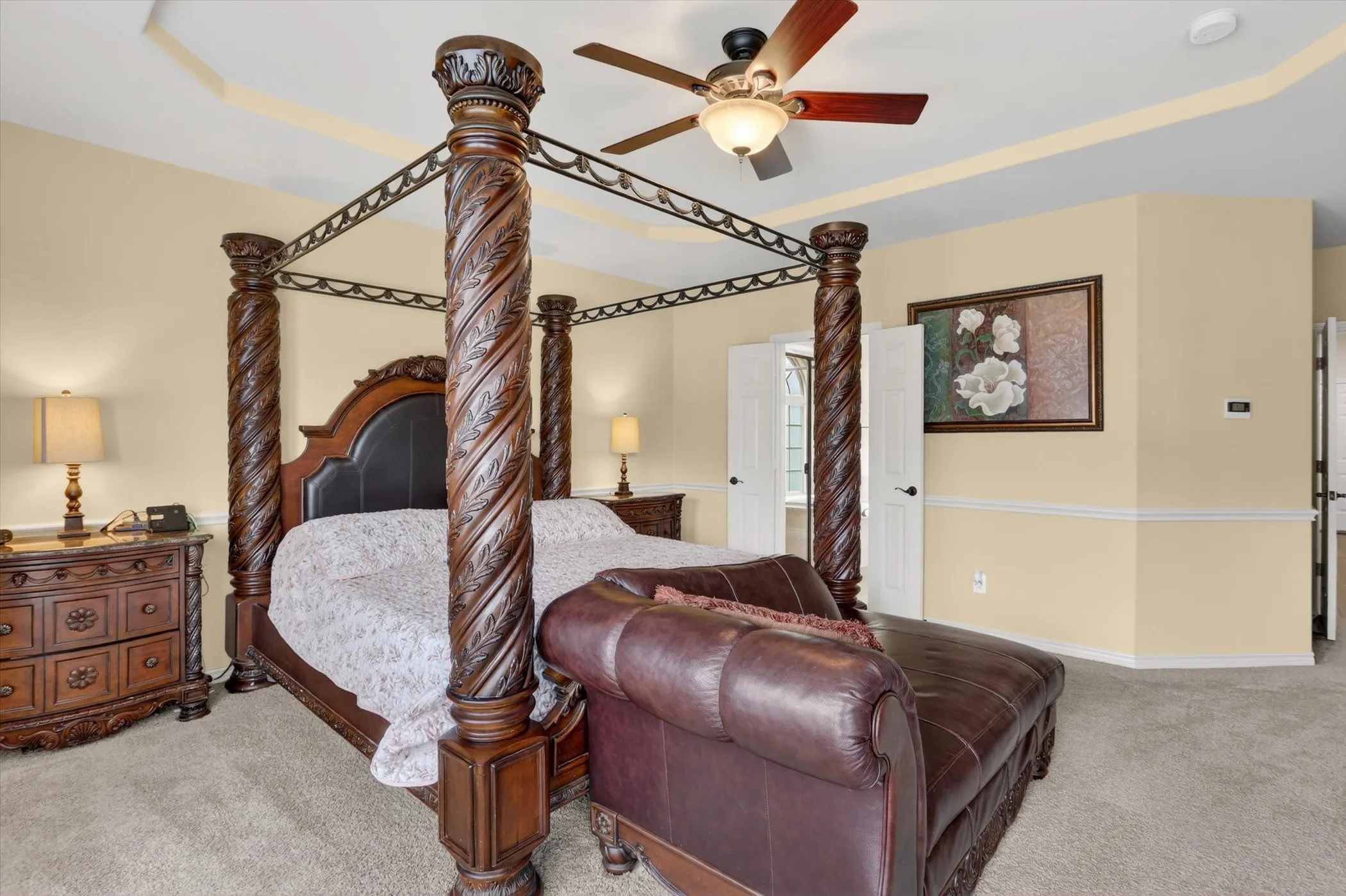 Carpeted room featuring a tray ceiling and a ceiling fan with integrated lighting
