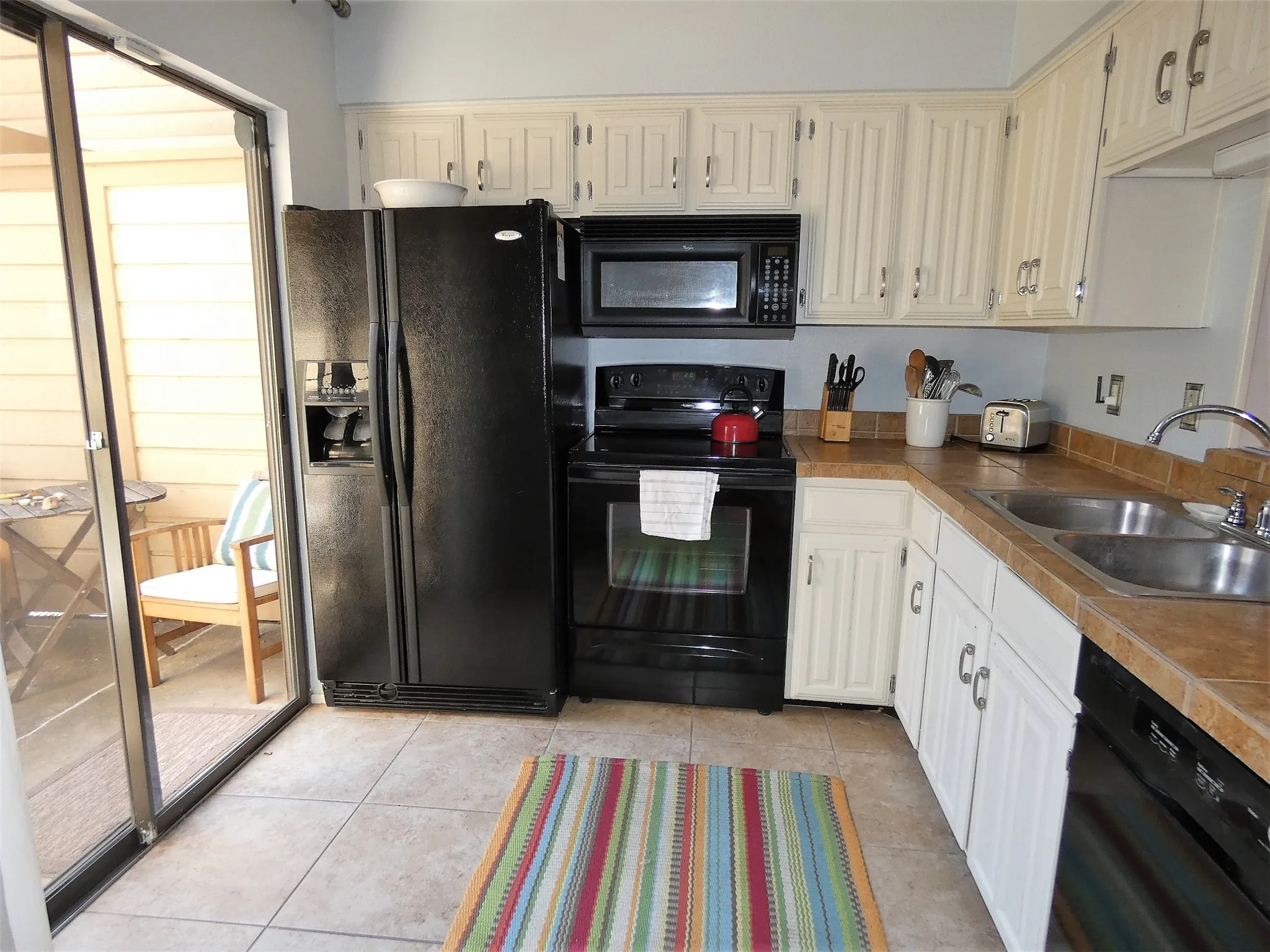 The kitchen is equipped with dishes, cookware, etc.  There is an opening from the kitchen to the dining area.