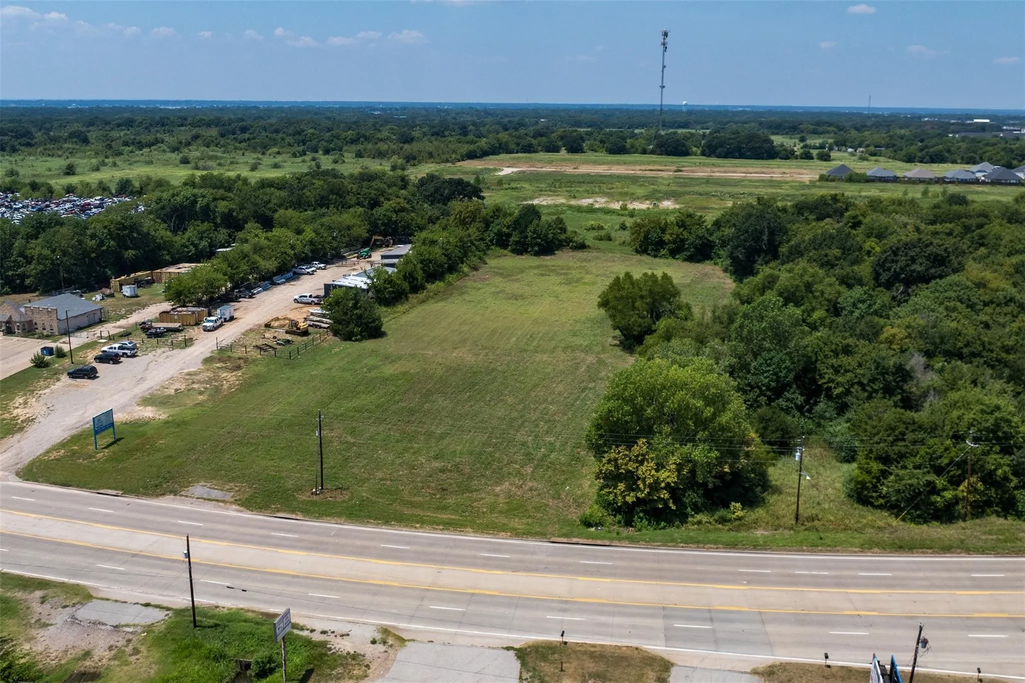 Expansive land parcel featuring a grass field and mature trees