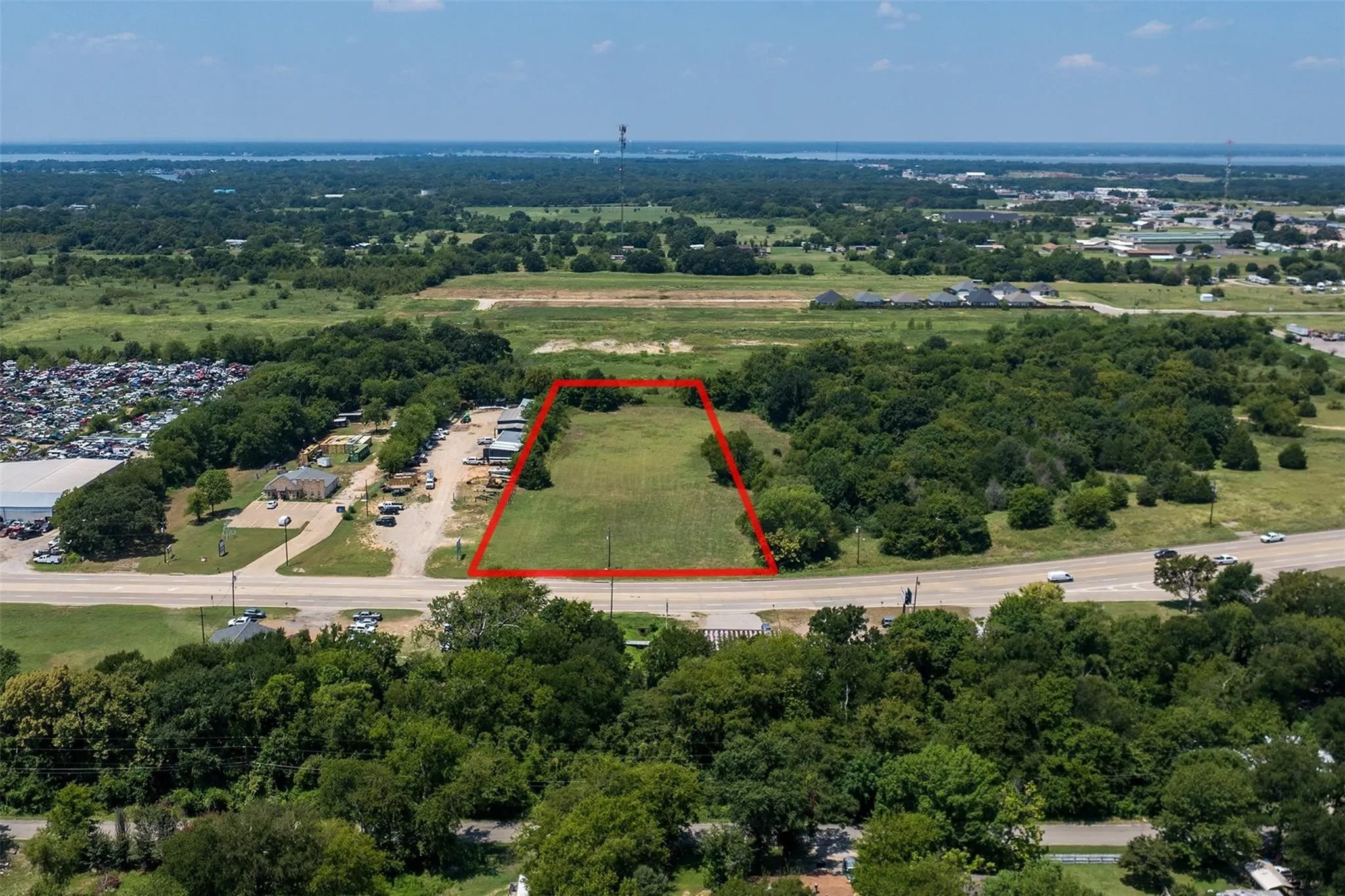 Expansive parcel of undeveloped land, delineated by a red outline, featuring a grassy expanse