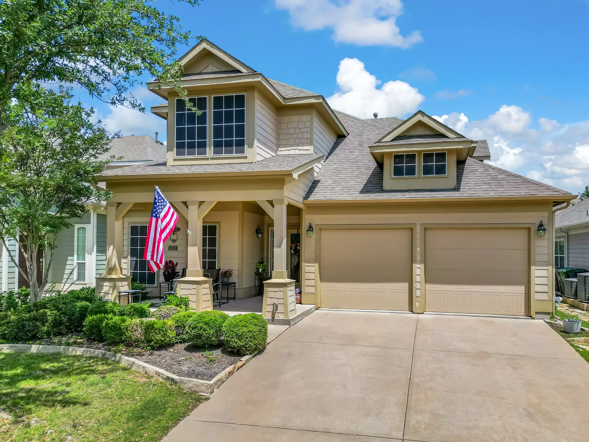 Inviting two-story residence with a covered front porch featuring stone accents