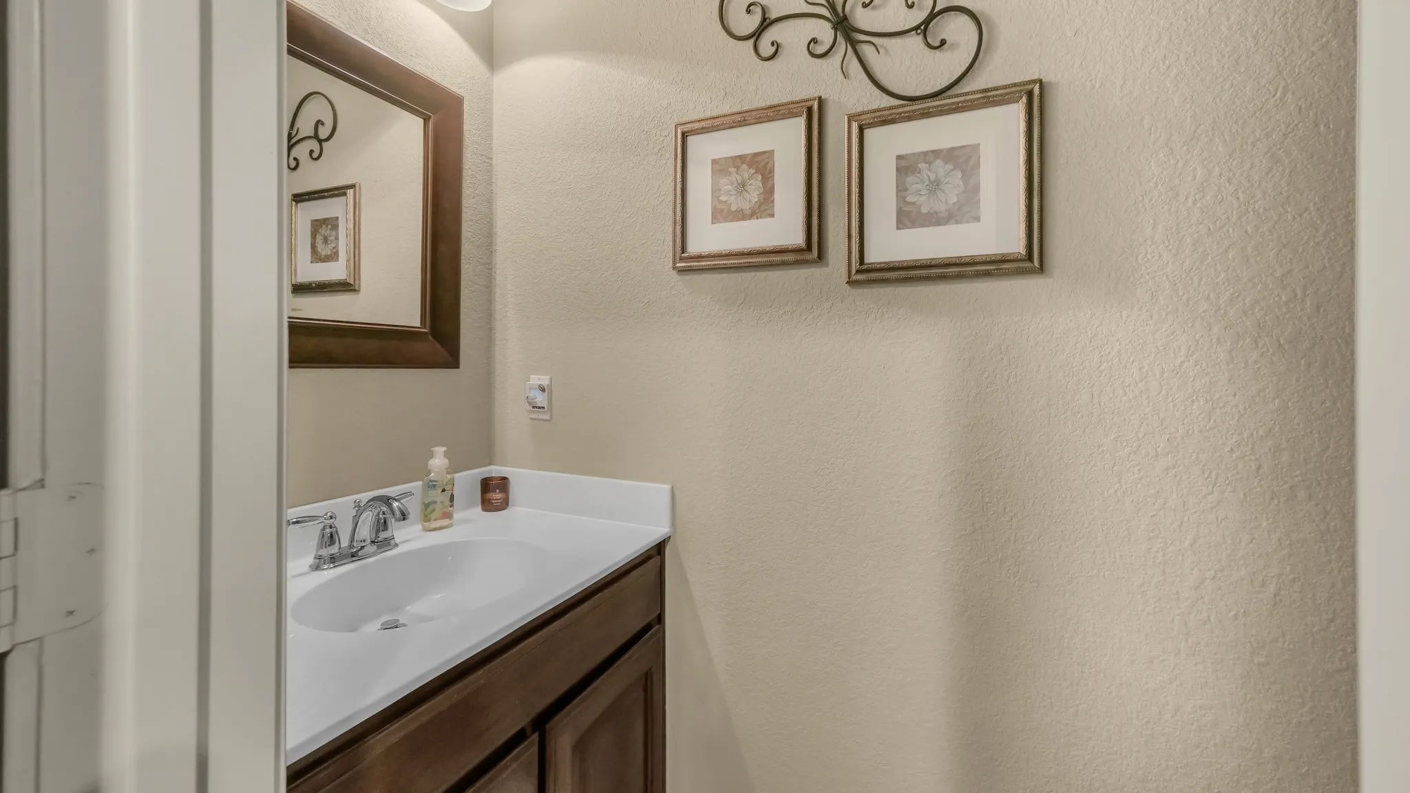 Powder room featuring a dark wood-finish vanity with a white countertop and an undermount sink