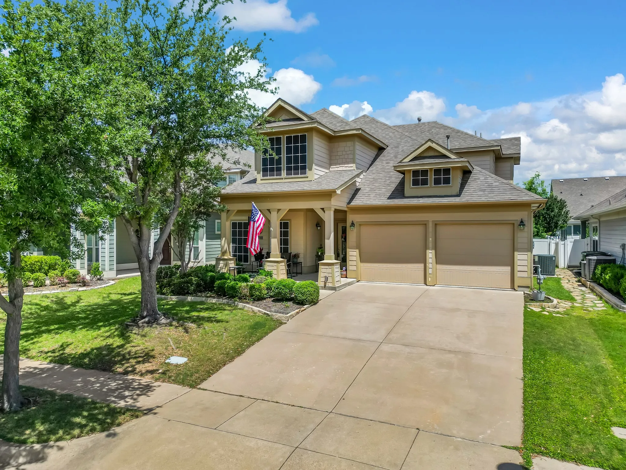 Two-story residence featuring a covered front porch with columns, a two-car garage, and a concrete driveway