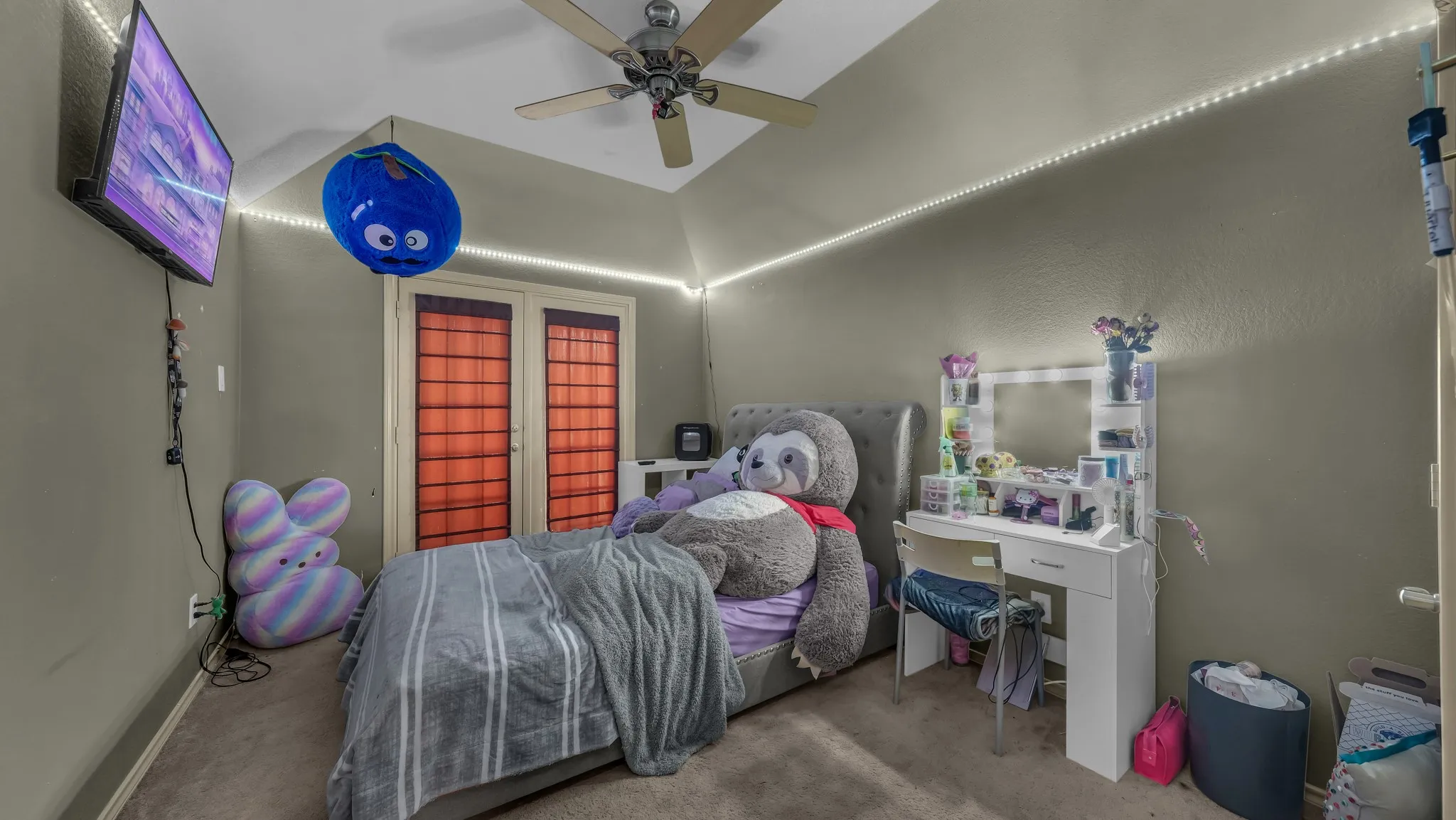 Carpeted room featuring a vaulted ceiling with a mounted ceiling fan