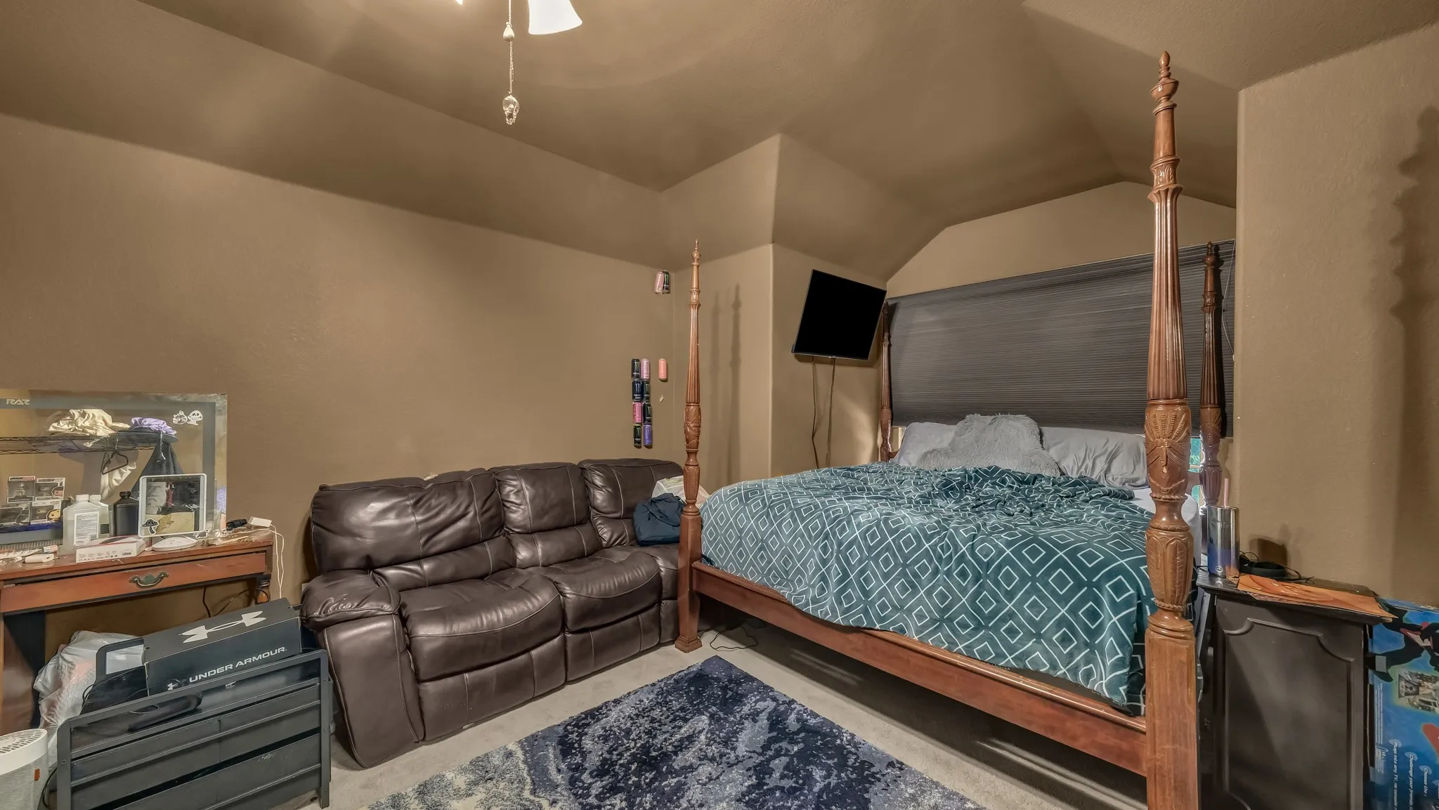 Spacious room featuring a four-poster bed, sloped ceilings, and wood-finish flooring