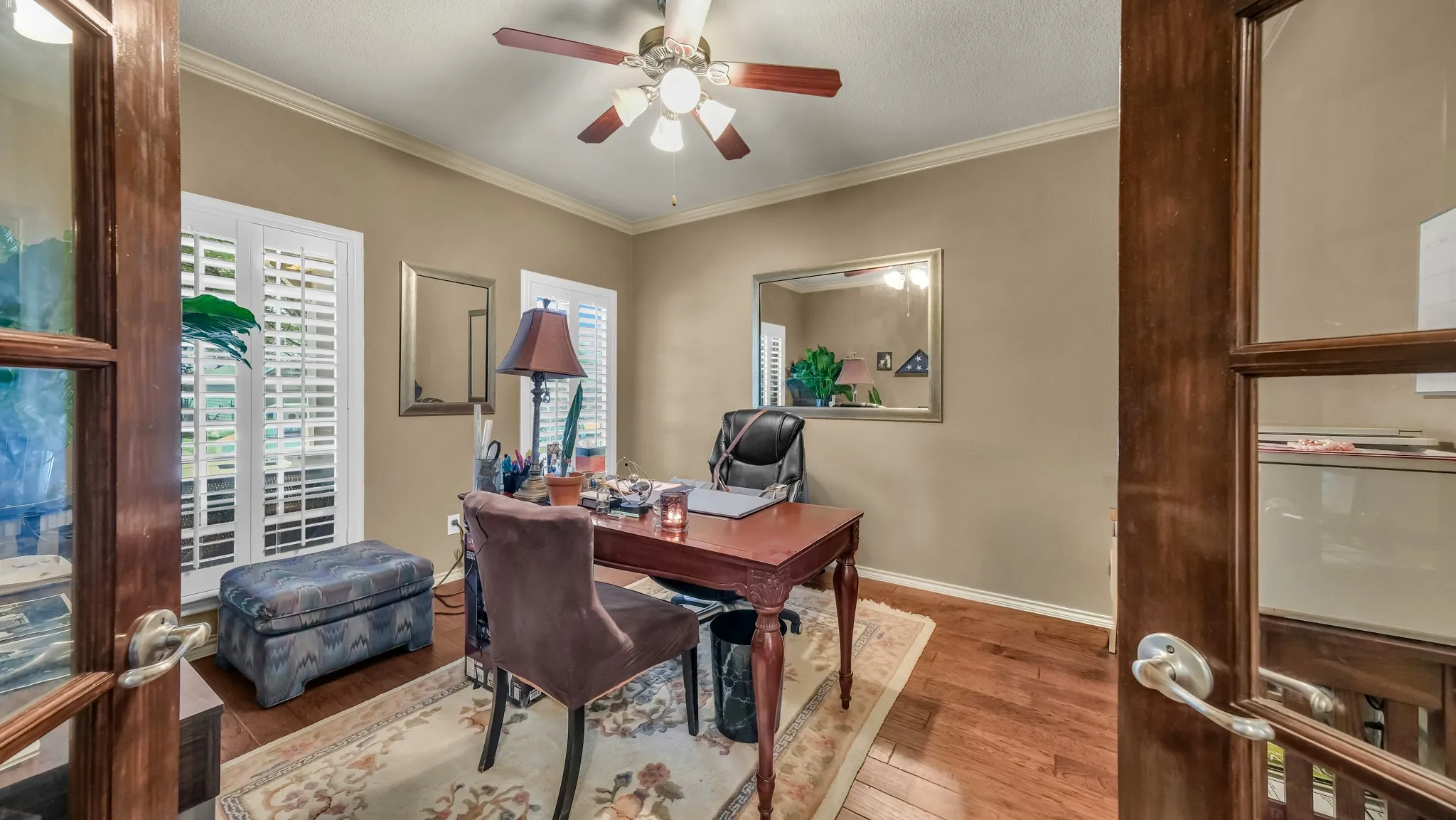Interior room featuring wood-finish flooring, neutral wall paint, and white crown molding