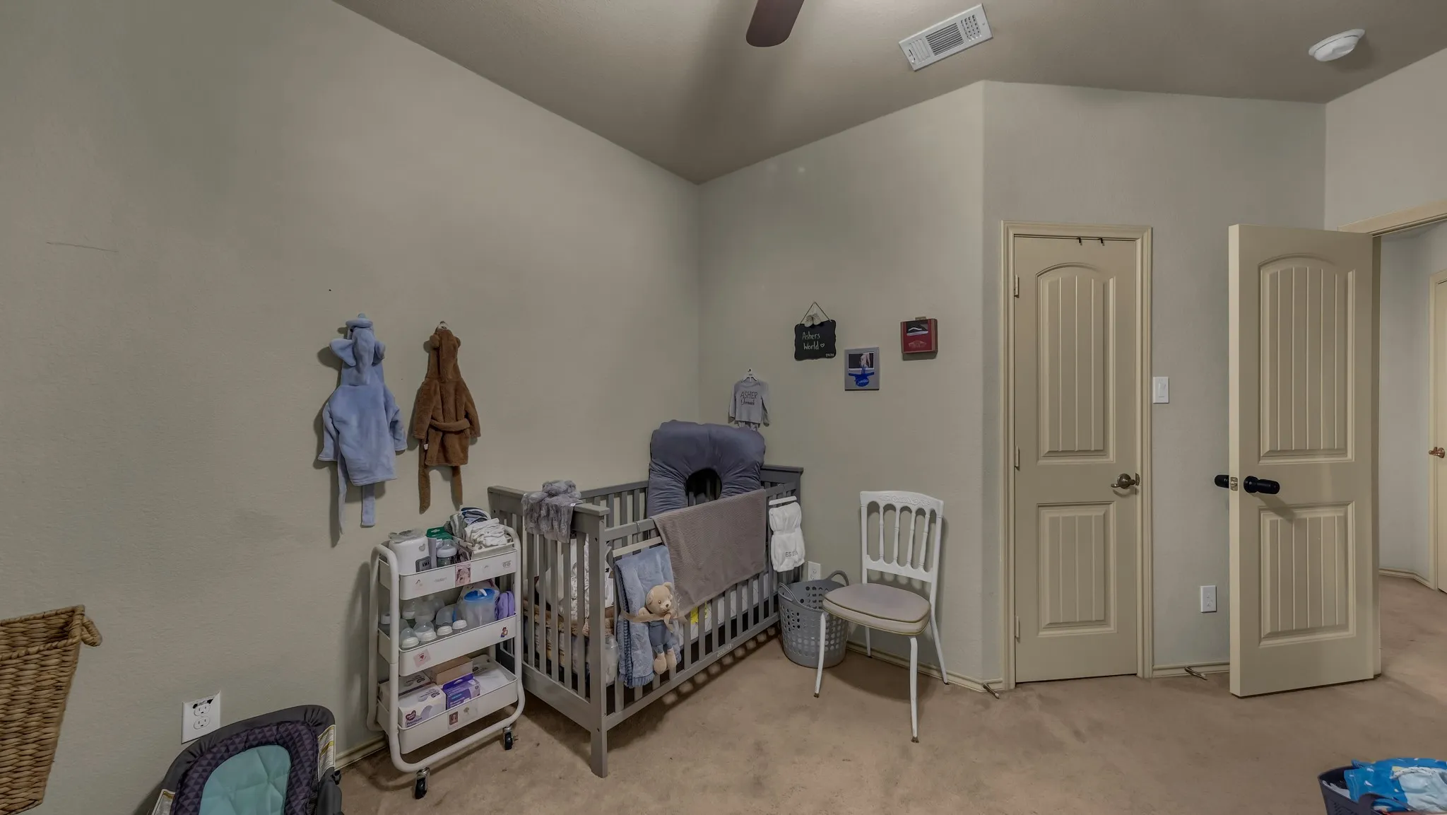 Carpeted interior space featuring a vaulted ceiling and neutral wall paint