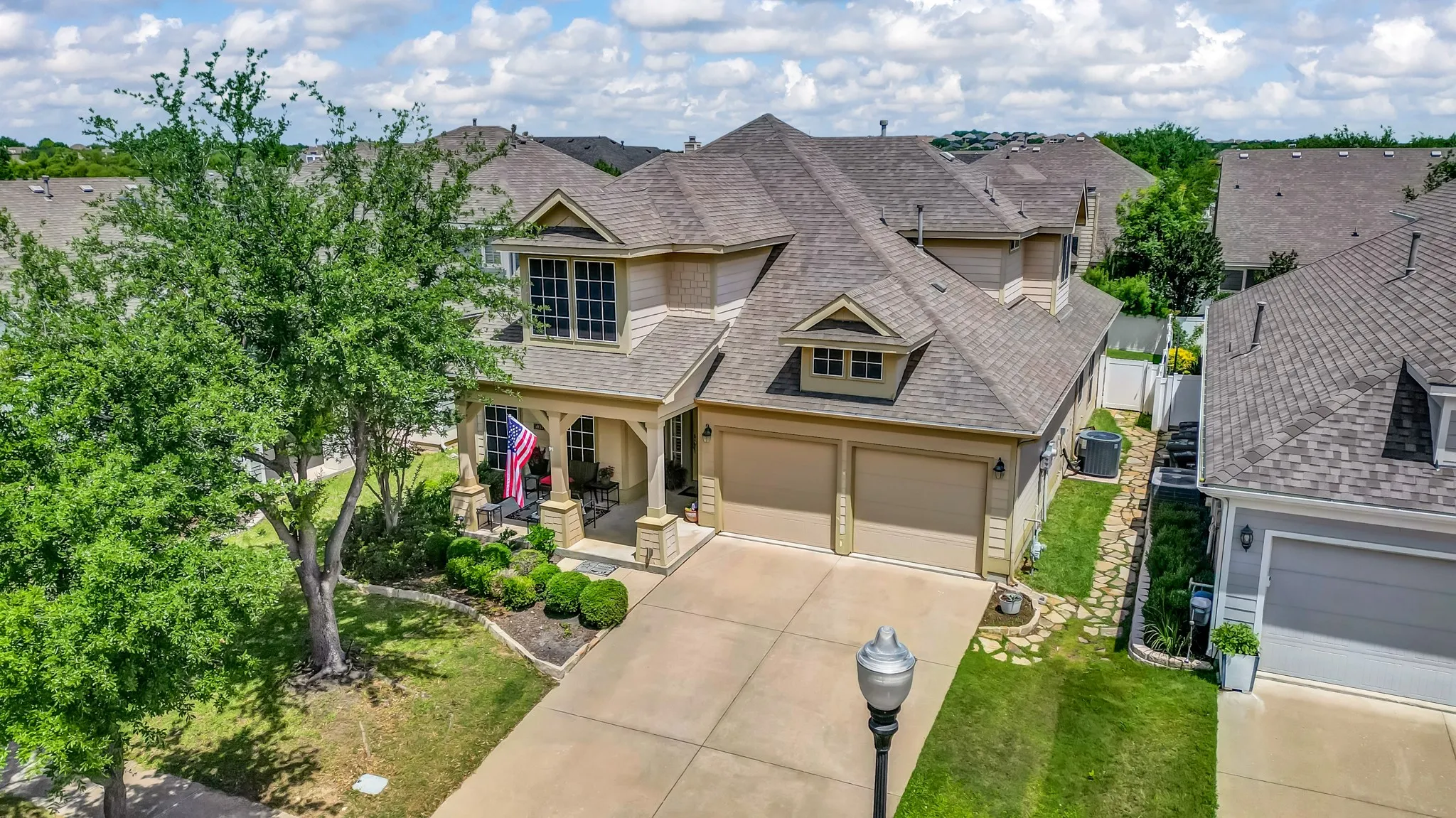 Traditional-style residence with a two-car garage, covered porch entry, and dormer windows