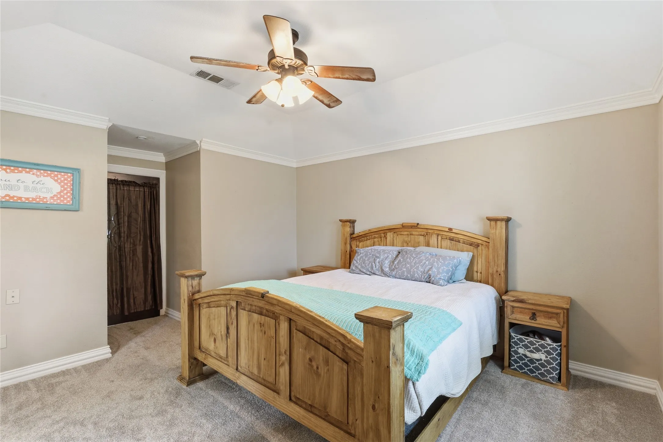 Carpeted room featuring a vaulted ceiling with crown molding and a ceiling fan