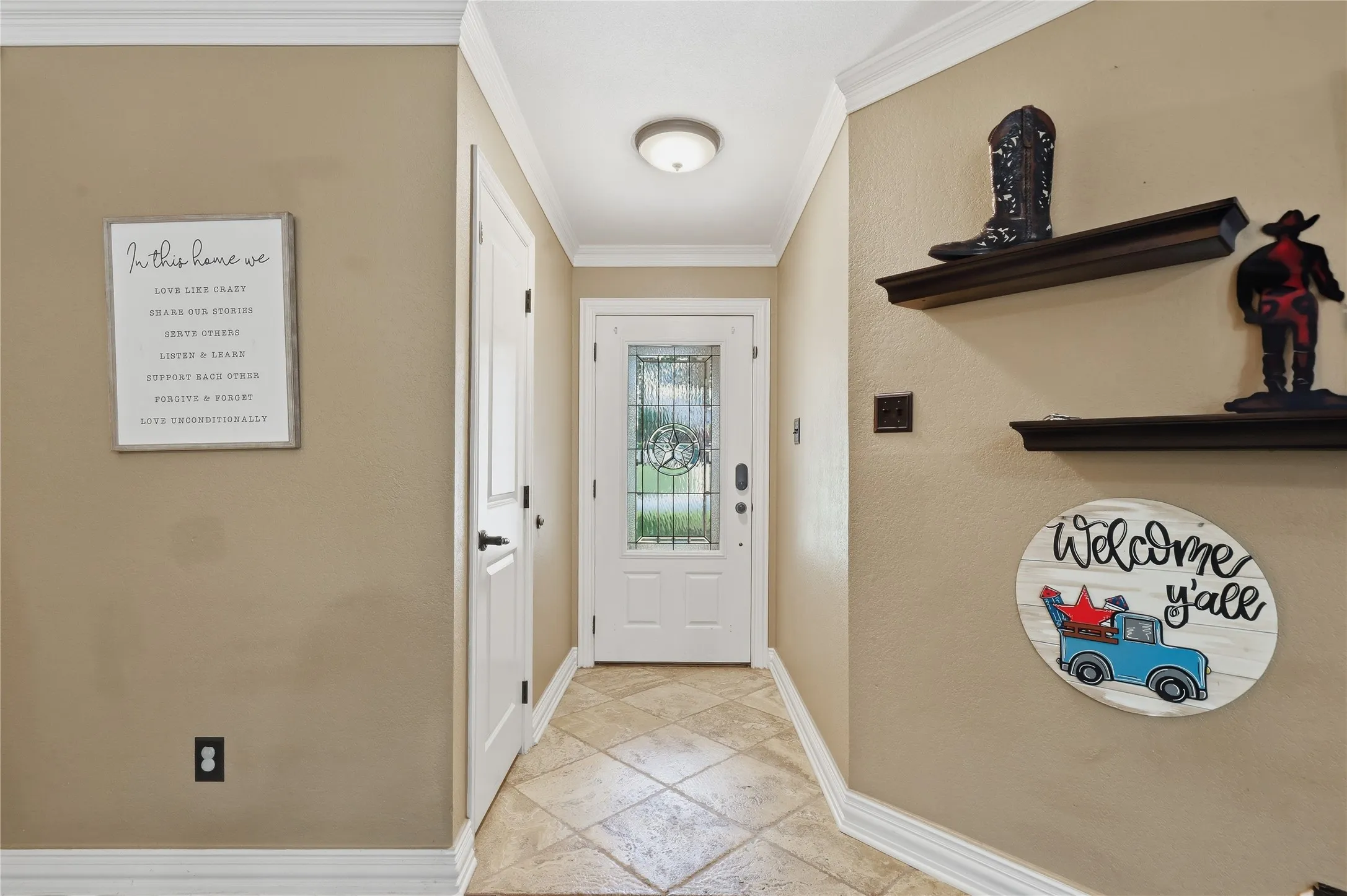 Entryway featuring tile flooring, crown molding, and a white front door with decorative glass inserts