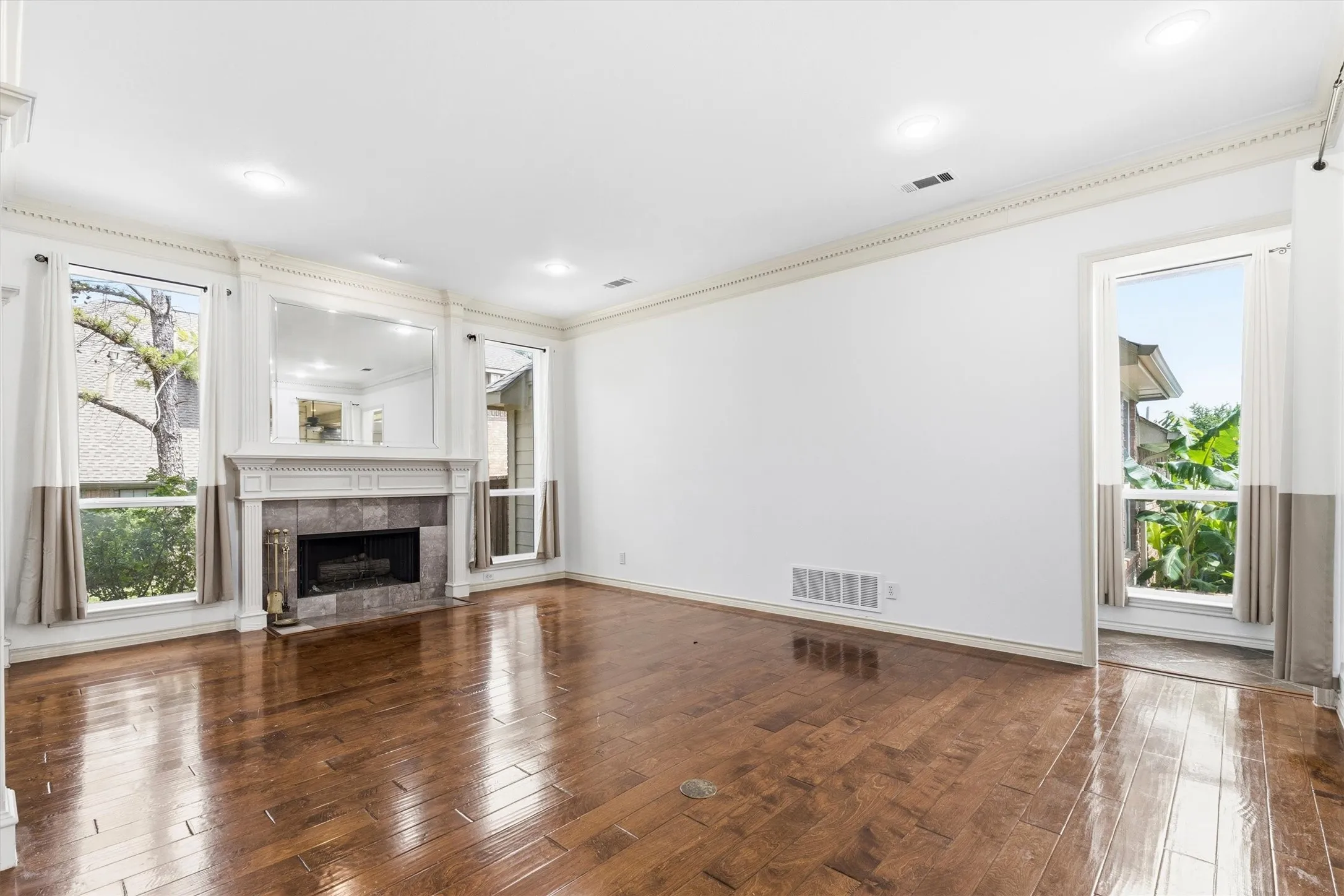 Formal living area featuring a fireplace with detailed mantel and large windows for natural light.