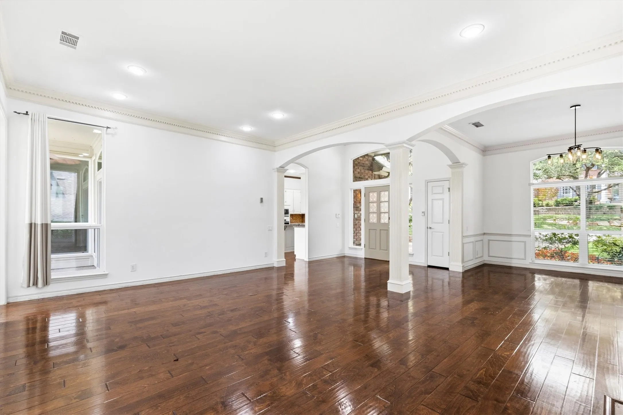 Spacious entry and living flow with architectural arches and sightlines into adjacent rooms.