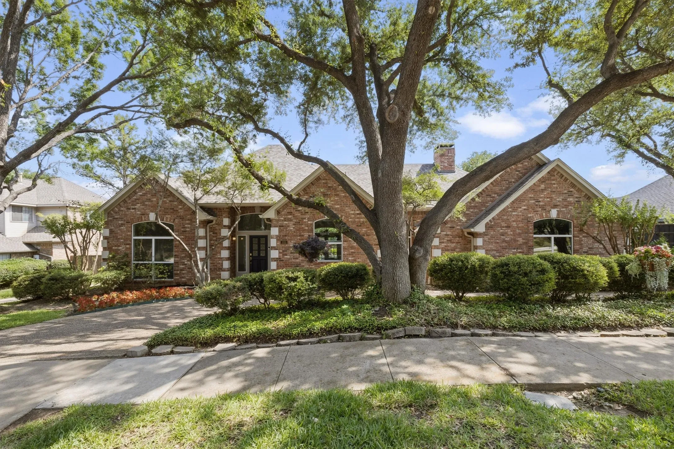 Soft twilight curb appeal with warm exterior lighting and manicured landscaping.