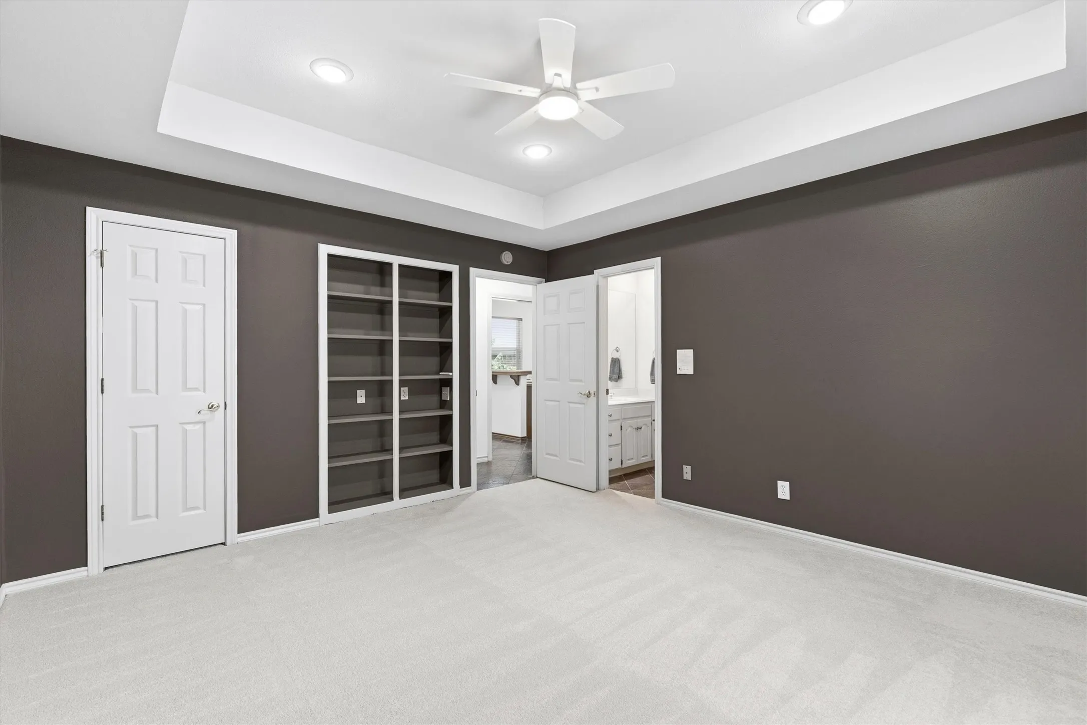 Third bedroom with plush new carpet, walk-in closet, and built in bookshelves.