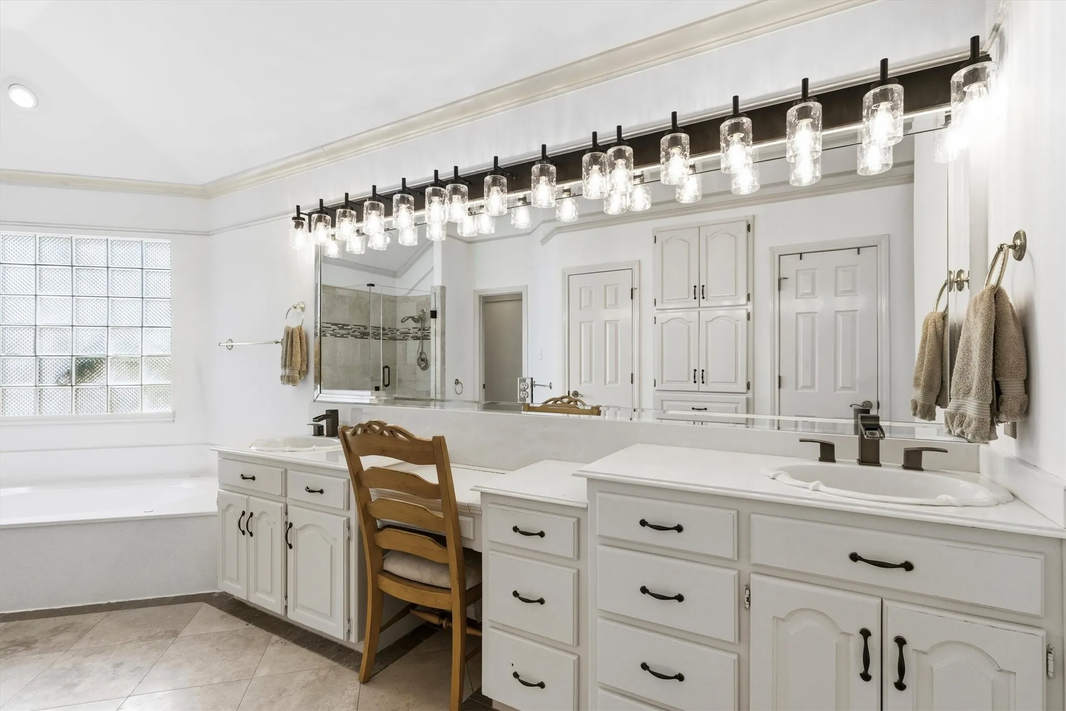 Oversized primary bath with dual vanities, garden tub, and walk-in shower.