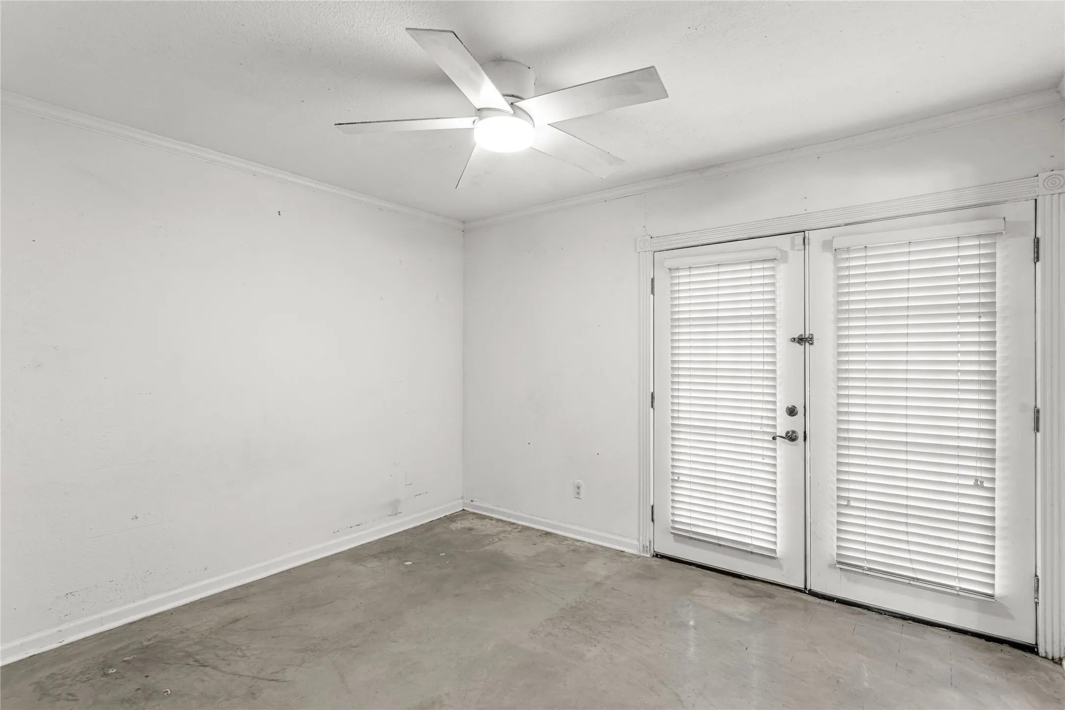 Room featuring double French doors with integrated blinds, a ceiling fan with integrated lighting, crown molding, and baseboards