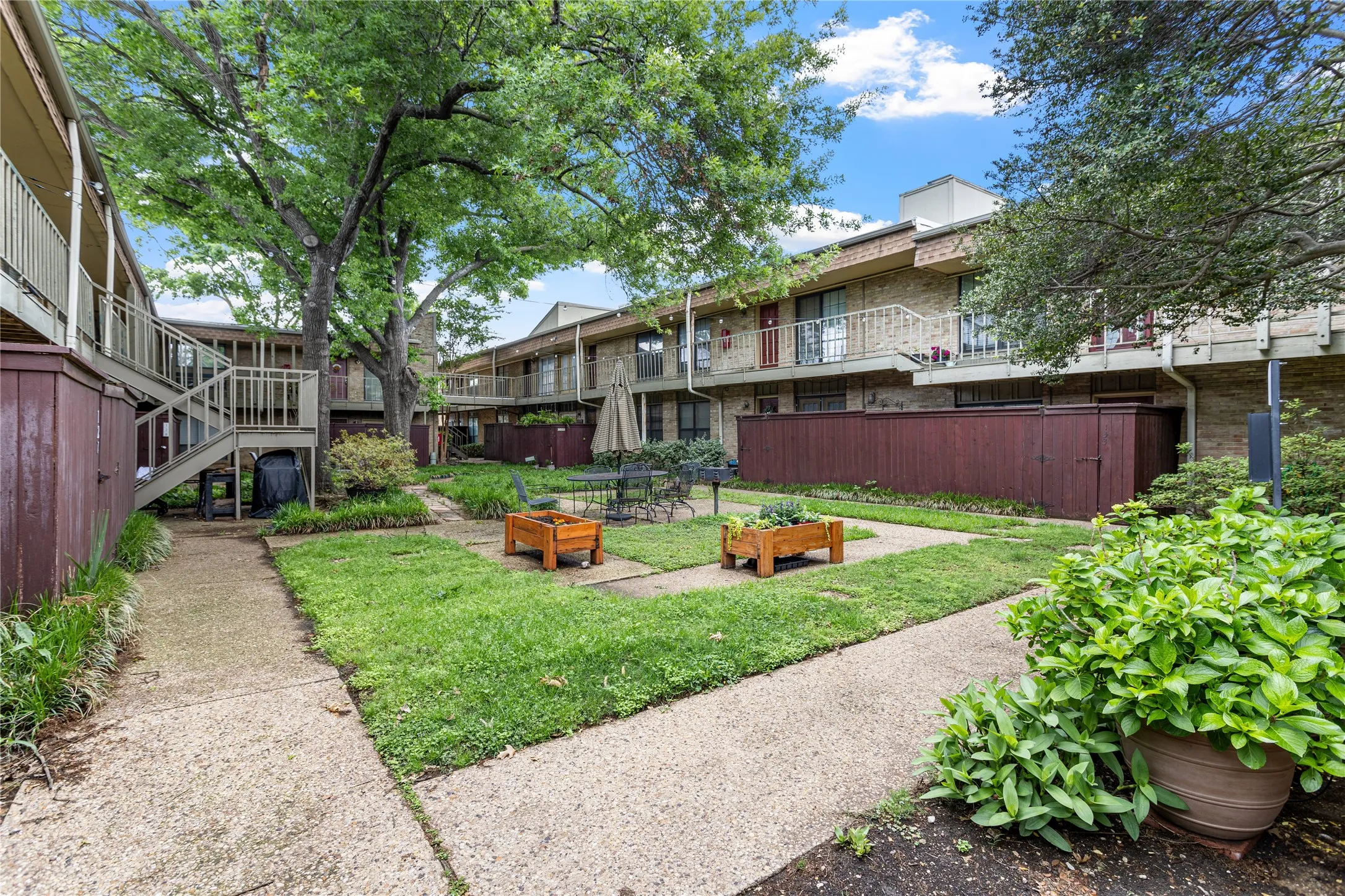Landscaped courtyard featuring concrete pathways and mature trees