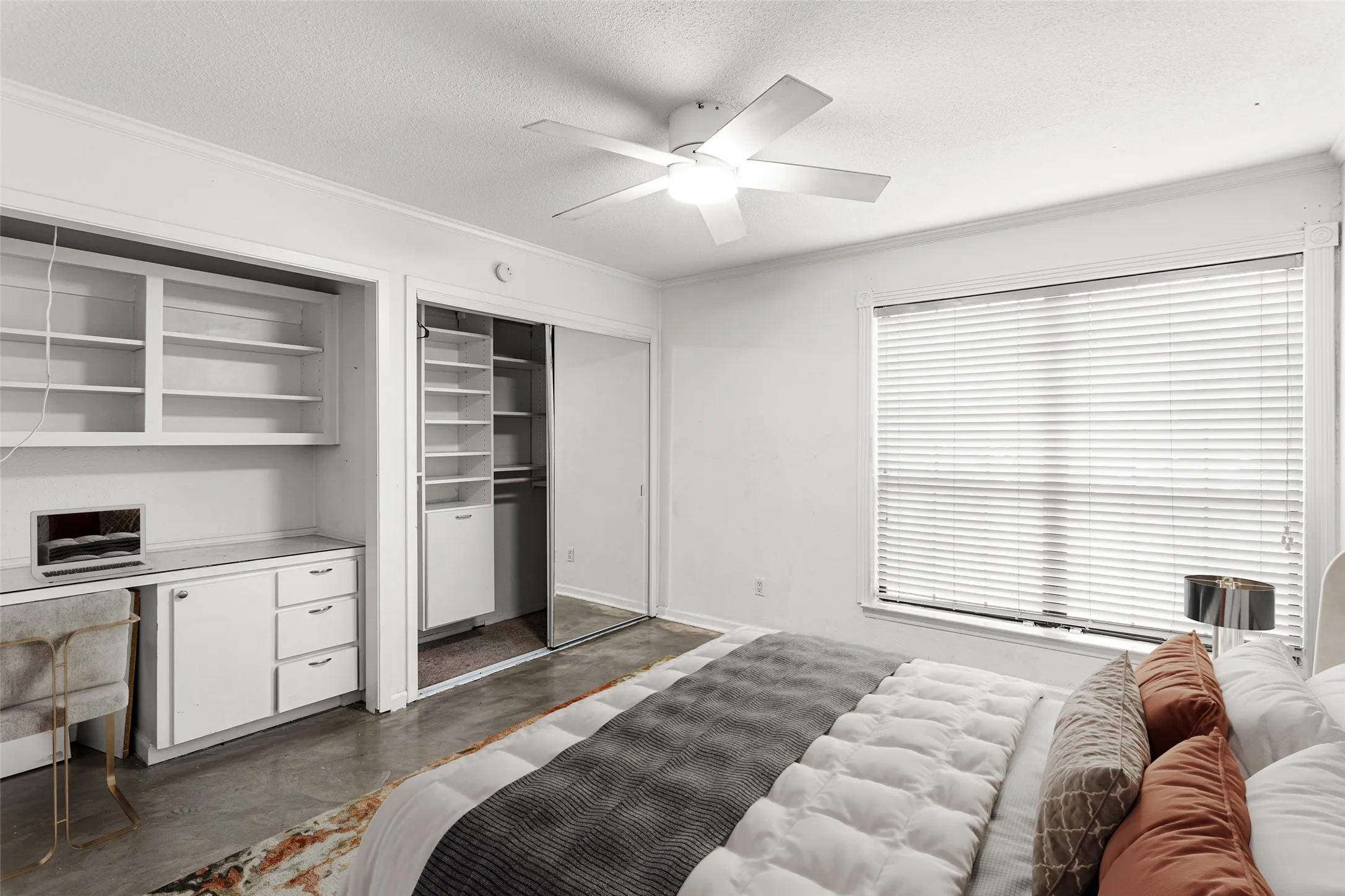 Virtually Staged Spacious room featuring a ceiling fan, a large window with blinds, and polished concrete flooring