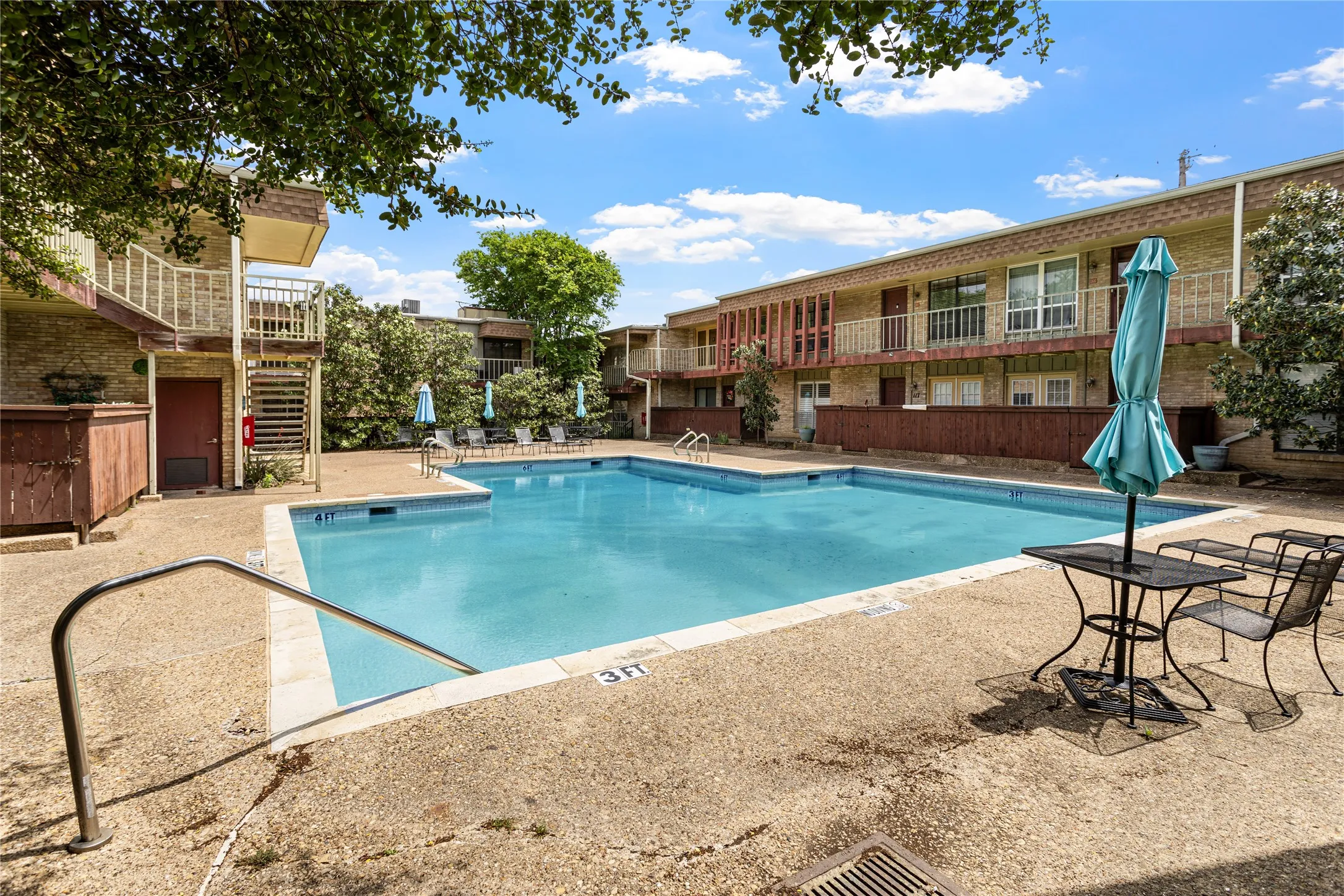 Community swimming pool surrounded by a concrete deck