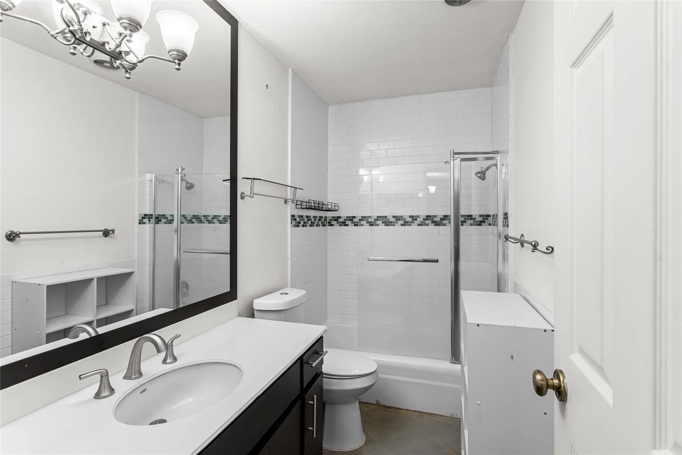 Bathroom featuring a single vanity with a white countertop, an oval undermount sink, and a large wall mirror