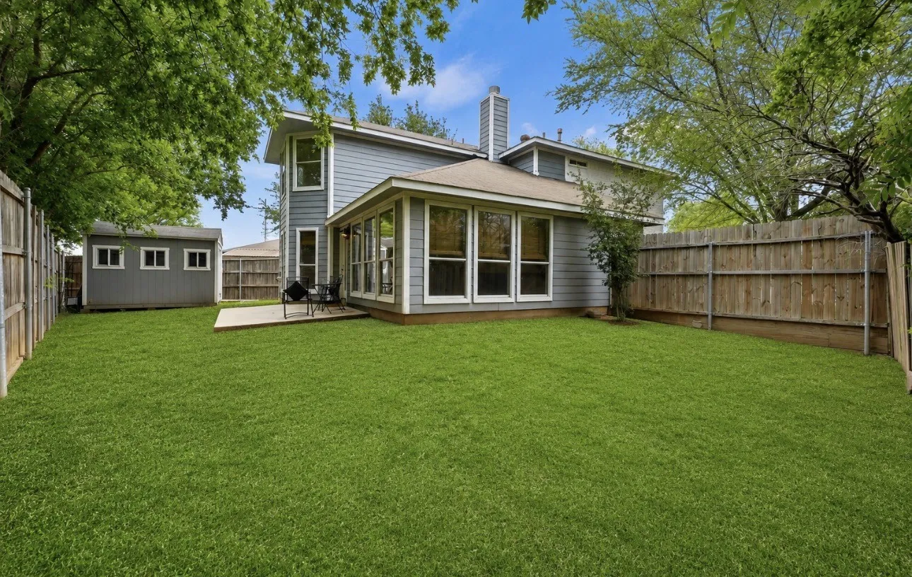Expansive fenced backyard featuring a detached storage shed, a concrete patio, and living room with multiple windows. Sod will be add once in contract.