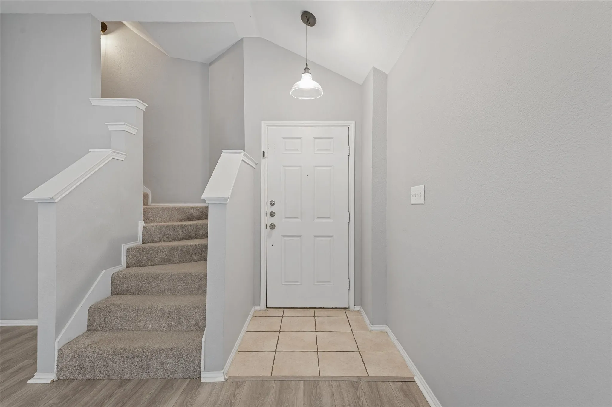 Entryway featuring a white paneled door, flush mount light fixture, and tile flooring
