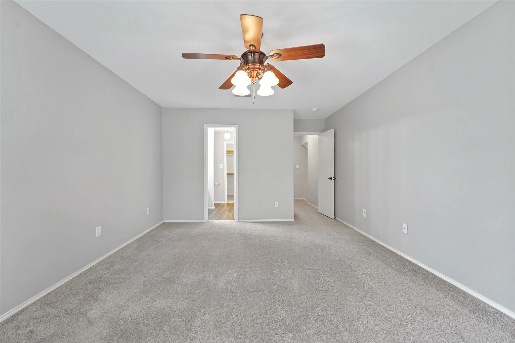 Spacious room featuring light gray carpeting and matching wall paint