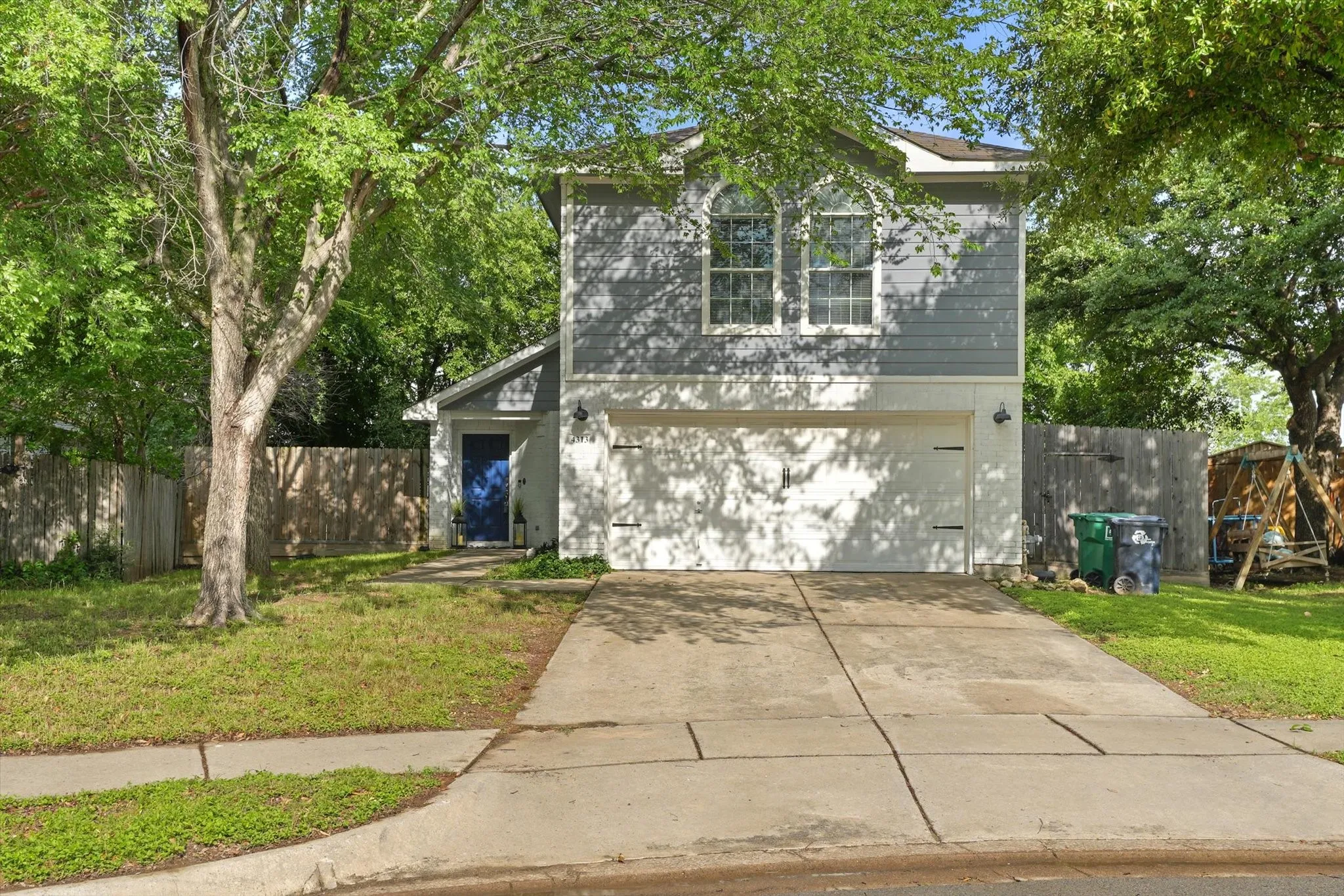 Gray siding exterior featuring a prominent two-car garage