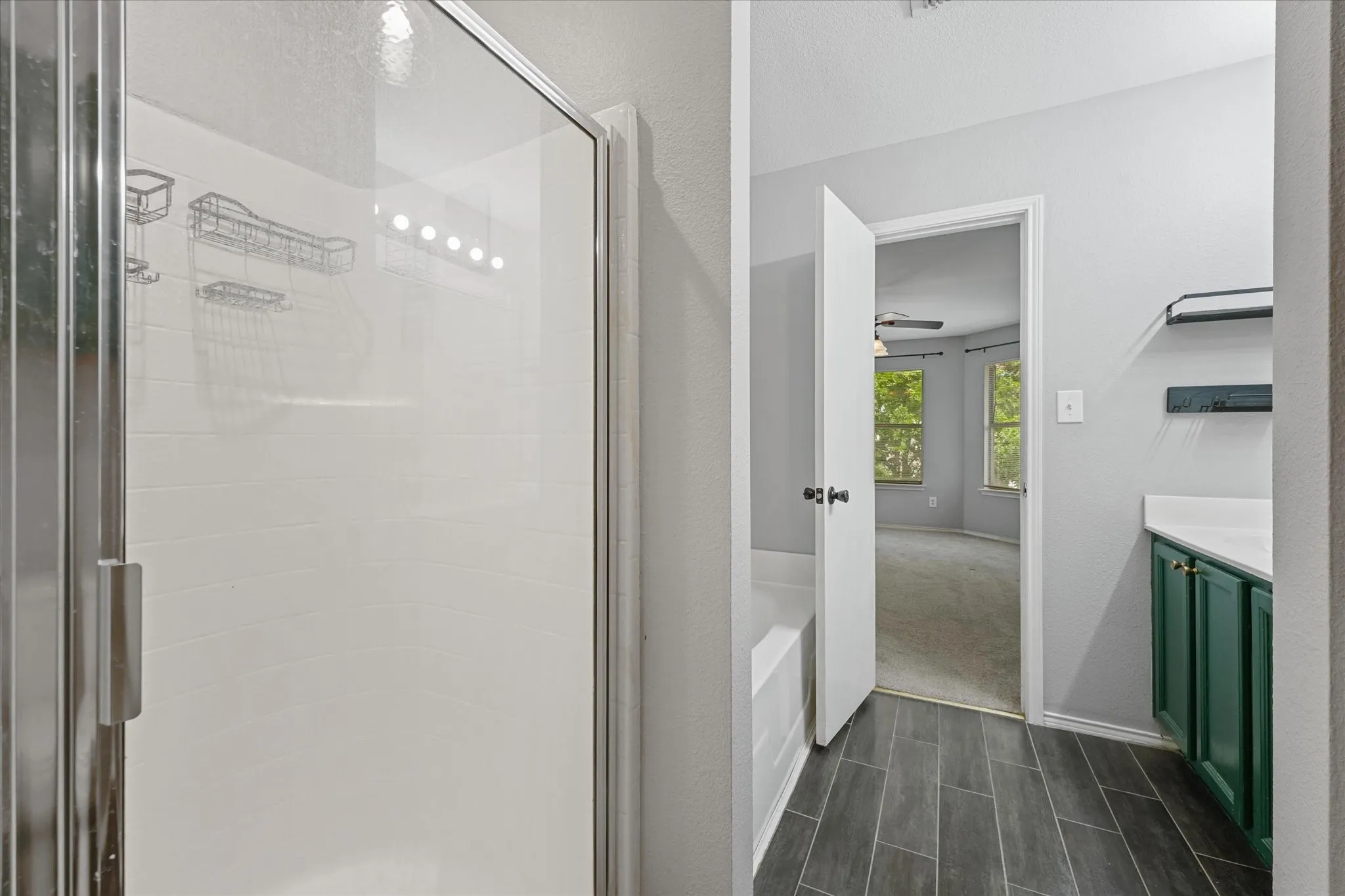 Shower with clear glass enclosure and tile-finish flooring