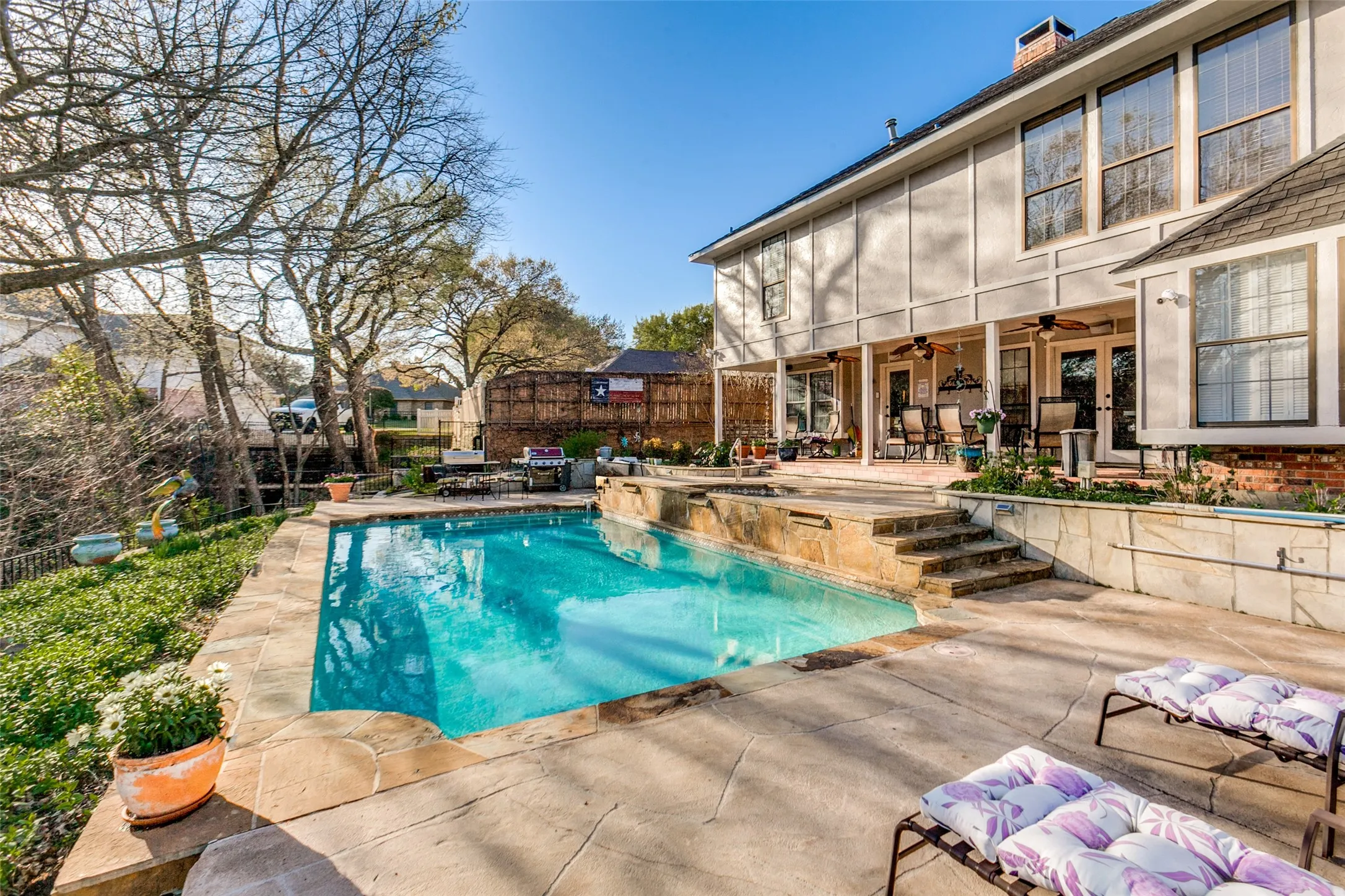Expansive outdoor living area featuring a rectangular pool with integrated spa