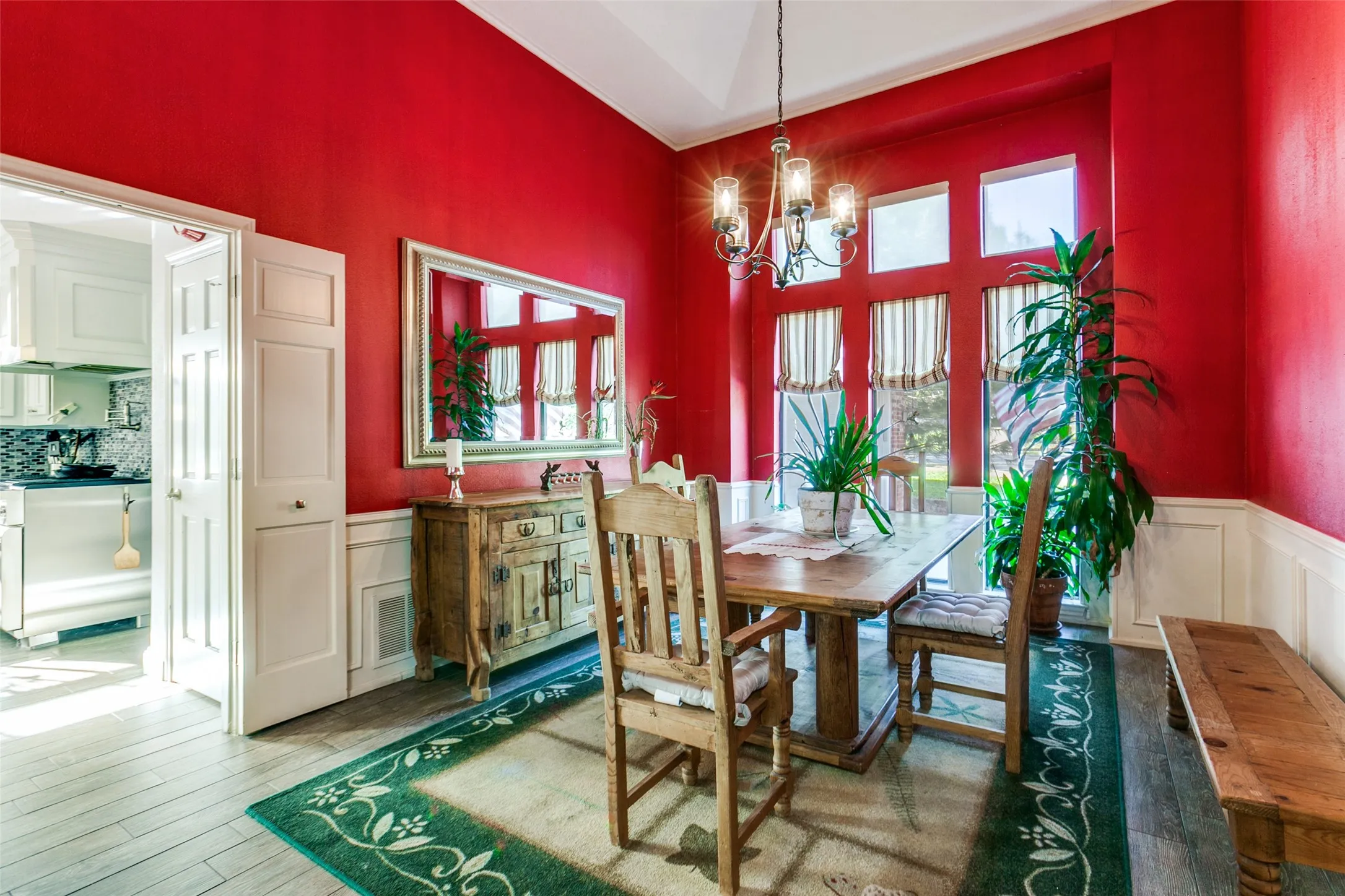 Dining area with red walls and white wainscoting