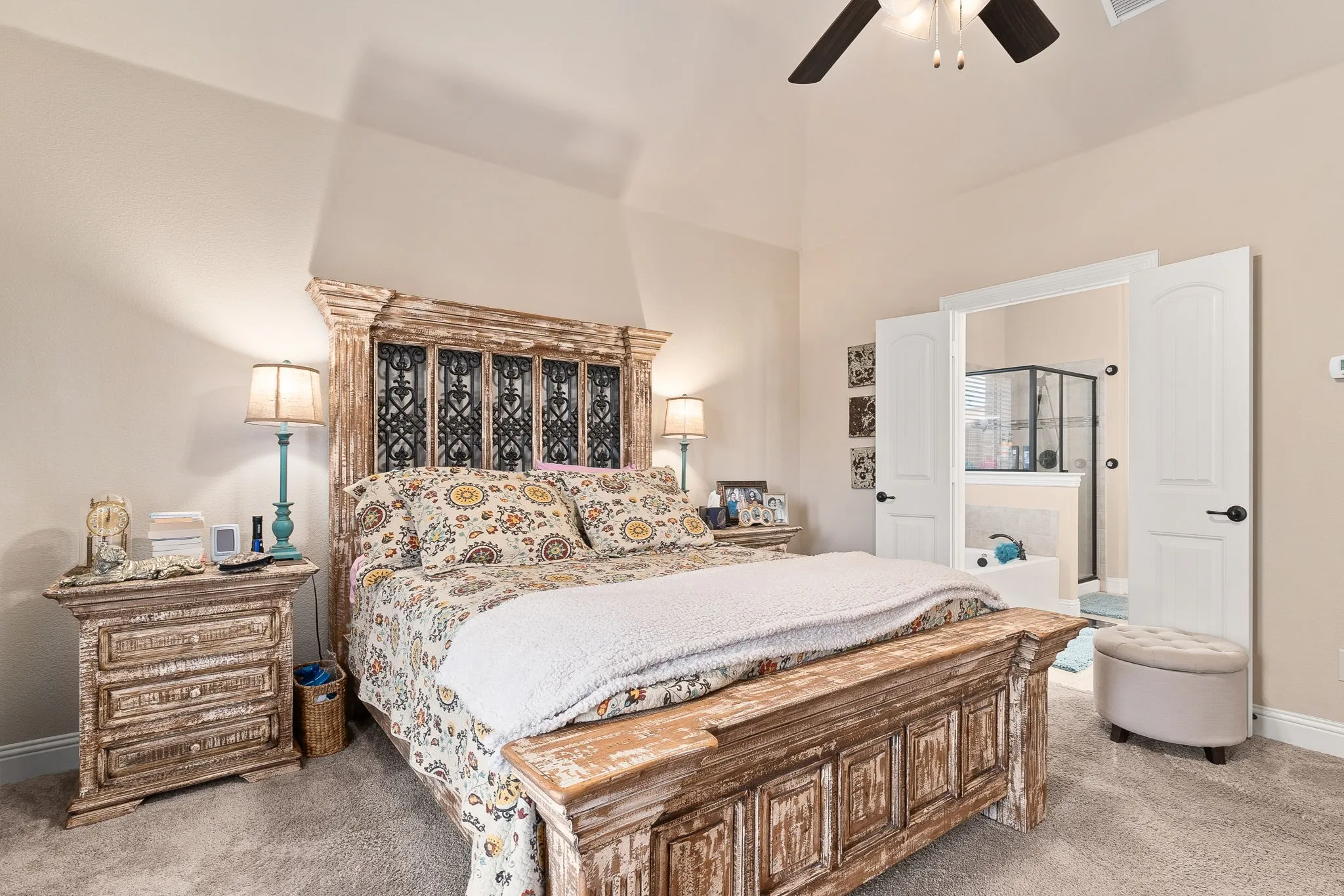 Carpeted bedroom featuring ceiling fan and vaulted ceiling