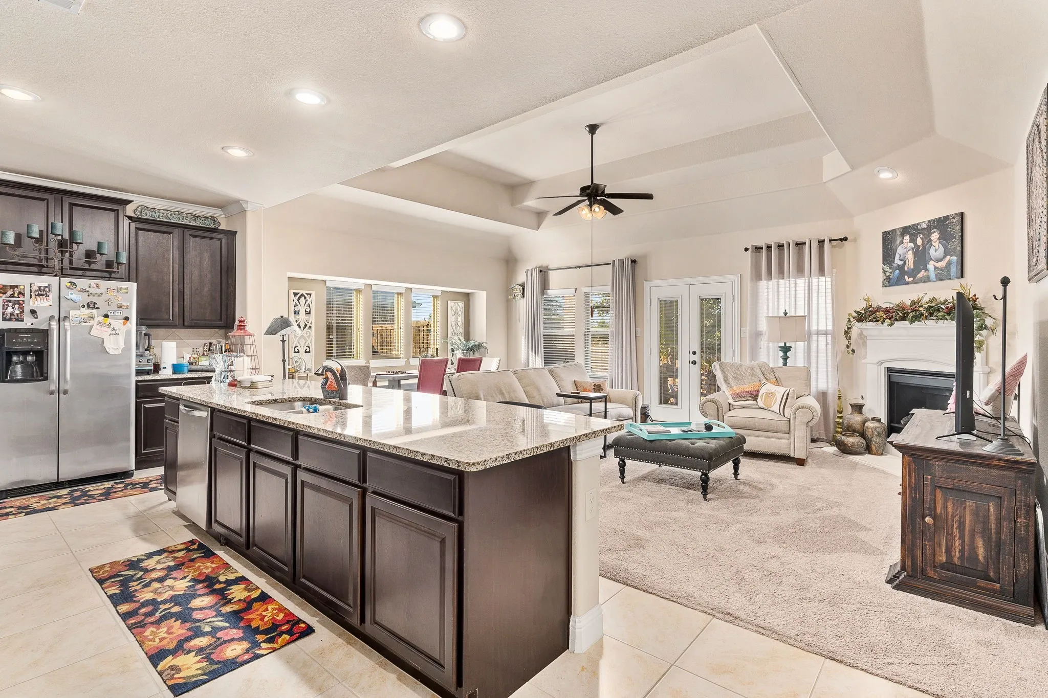 Kitchen featuring dark brown cabinetry, a center island with sink, light carpet, sink, and appliances with stainless steel finishes