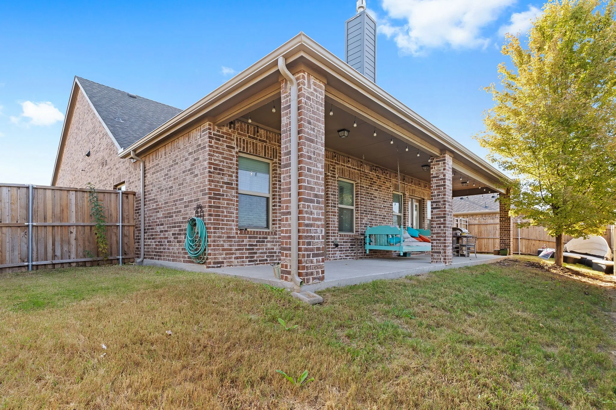 Rear view of house with a lawn and a patio area
