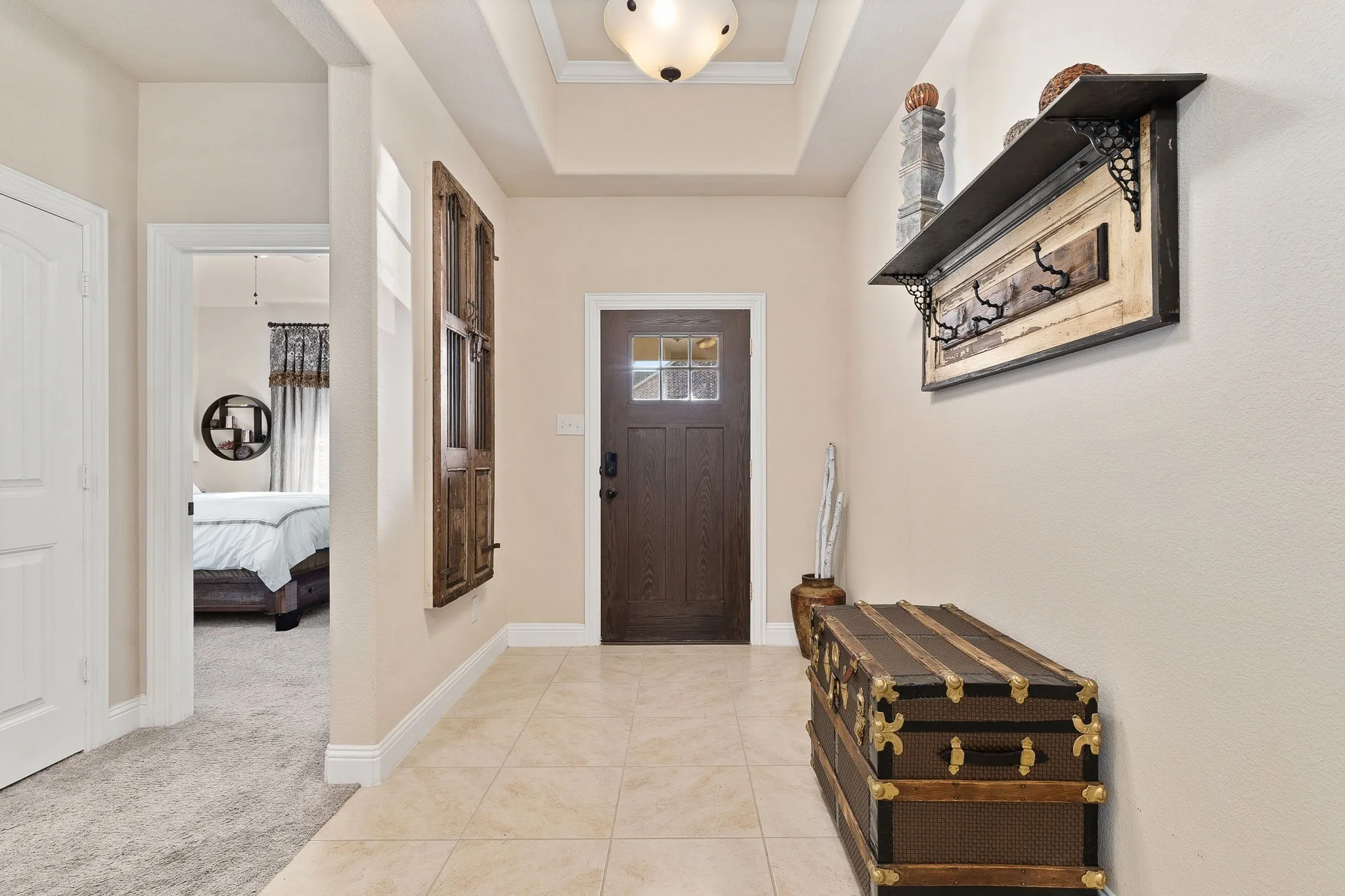 Carpeted foyer entrance with a tray ceiling