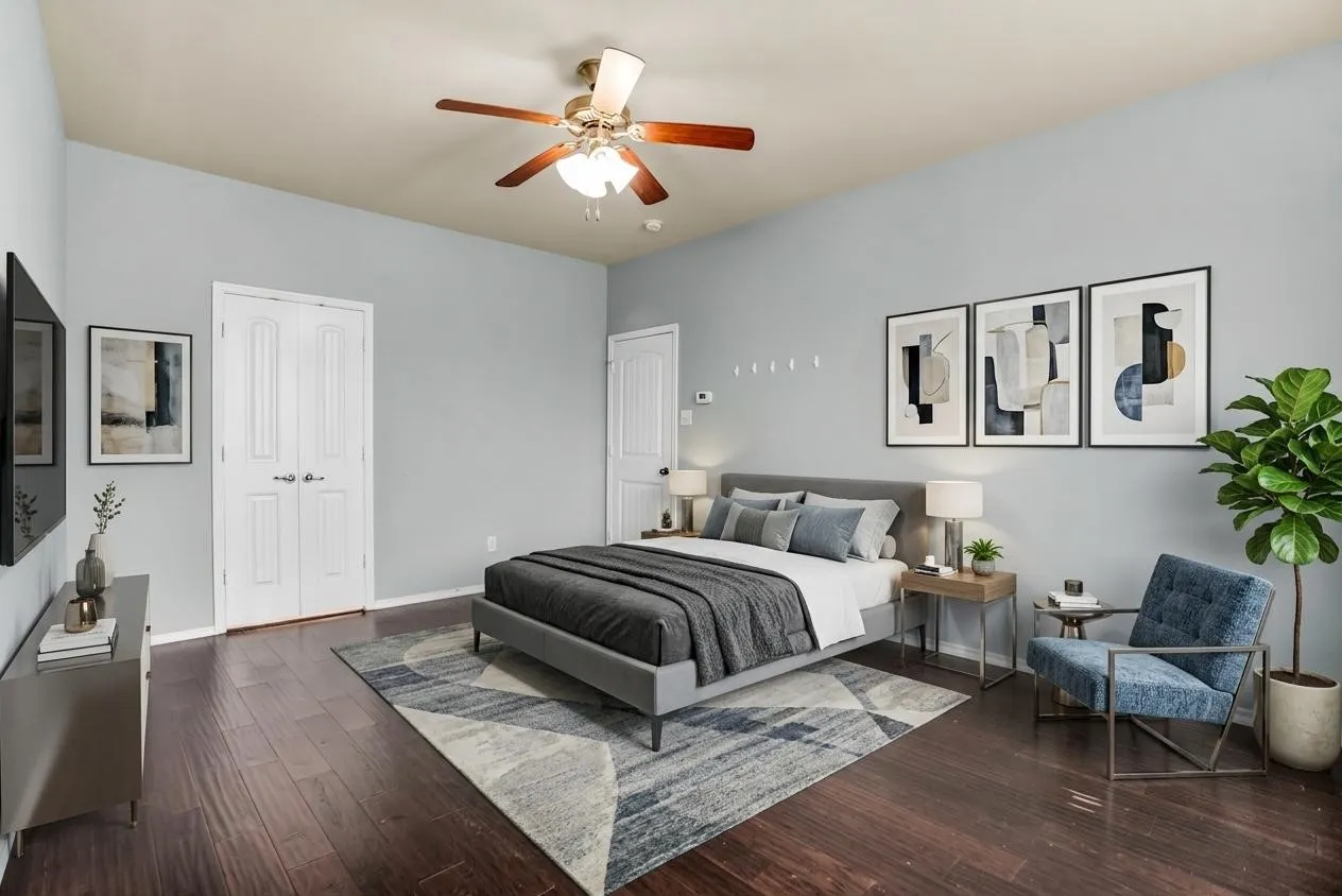 Virtual Staging -Spacious bedroom featuring rich wood-finish flooring and light gray walls