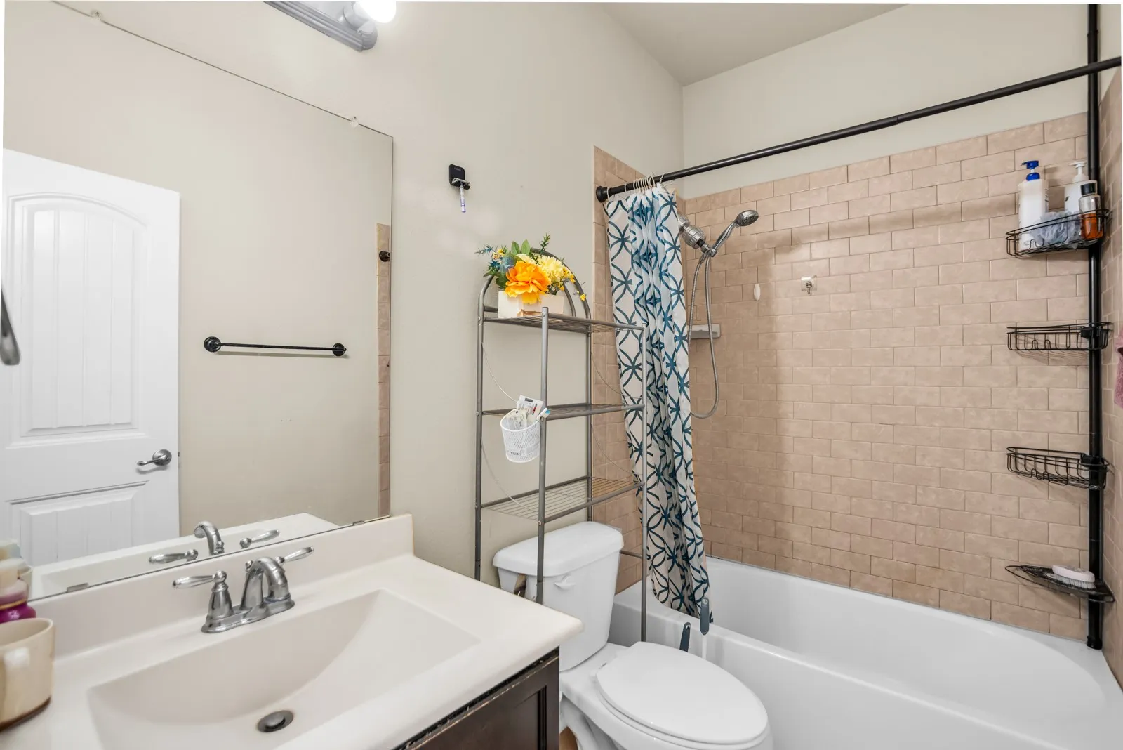 Bathroom featuring a white vanity with an integrated sink, chrome faucet, and expansive mirror