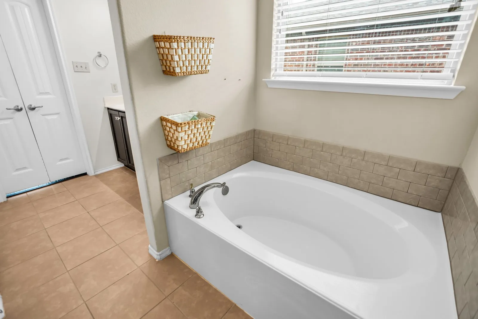Soaking tub with chrome fixtures and surrounding tile accents