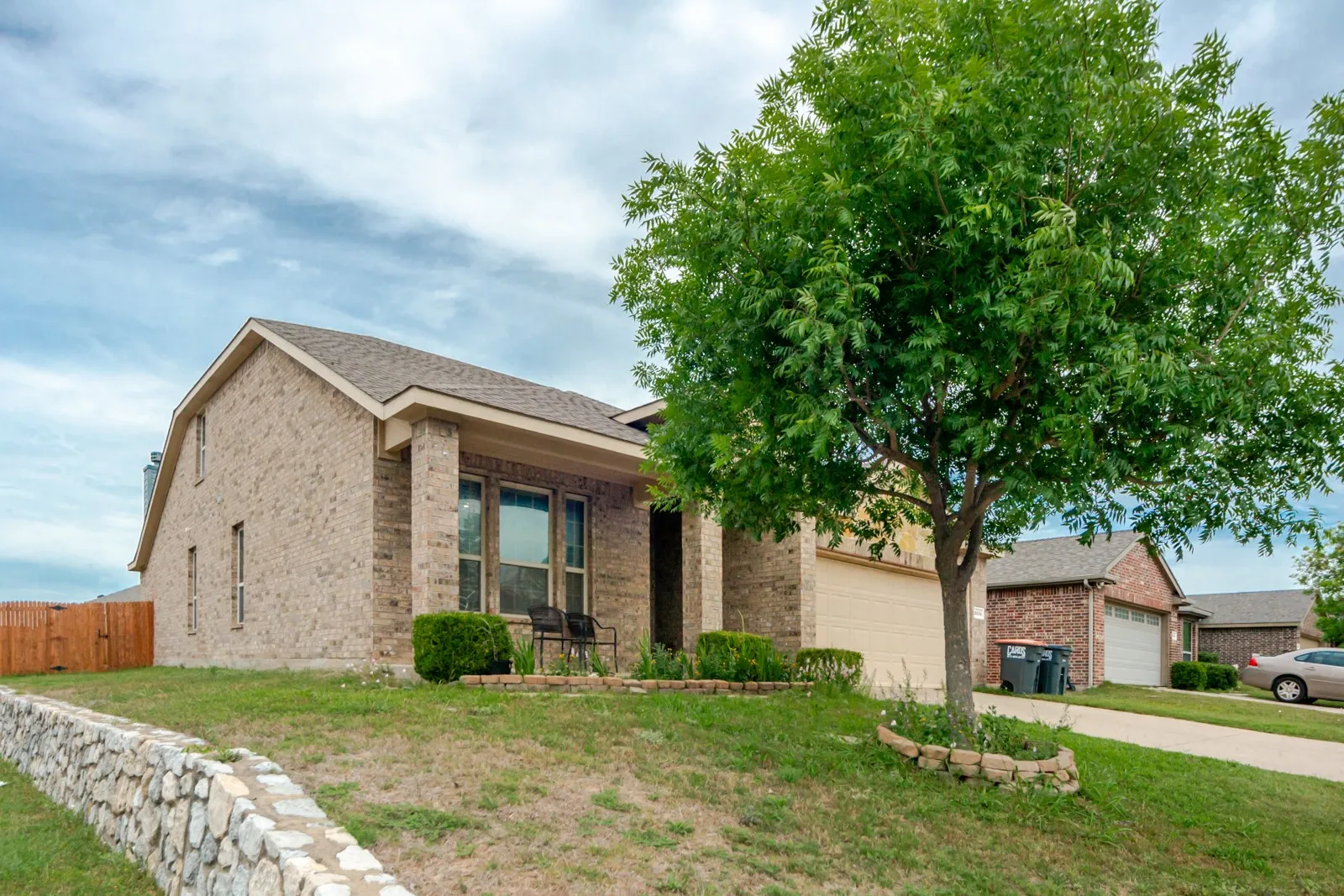 Brick exterior featuring a covered entry and attached garage