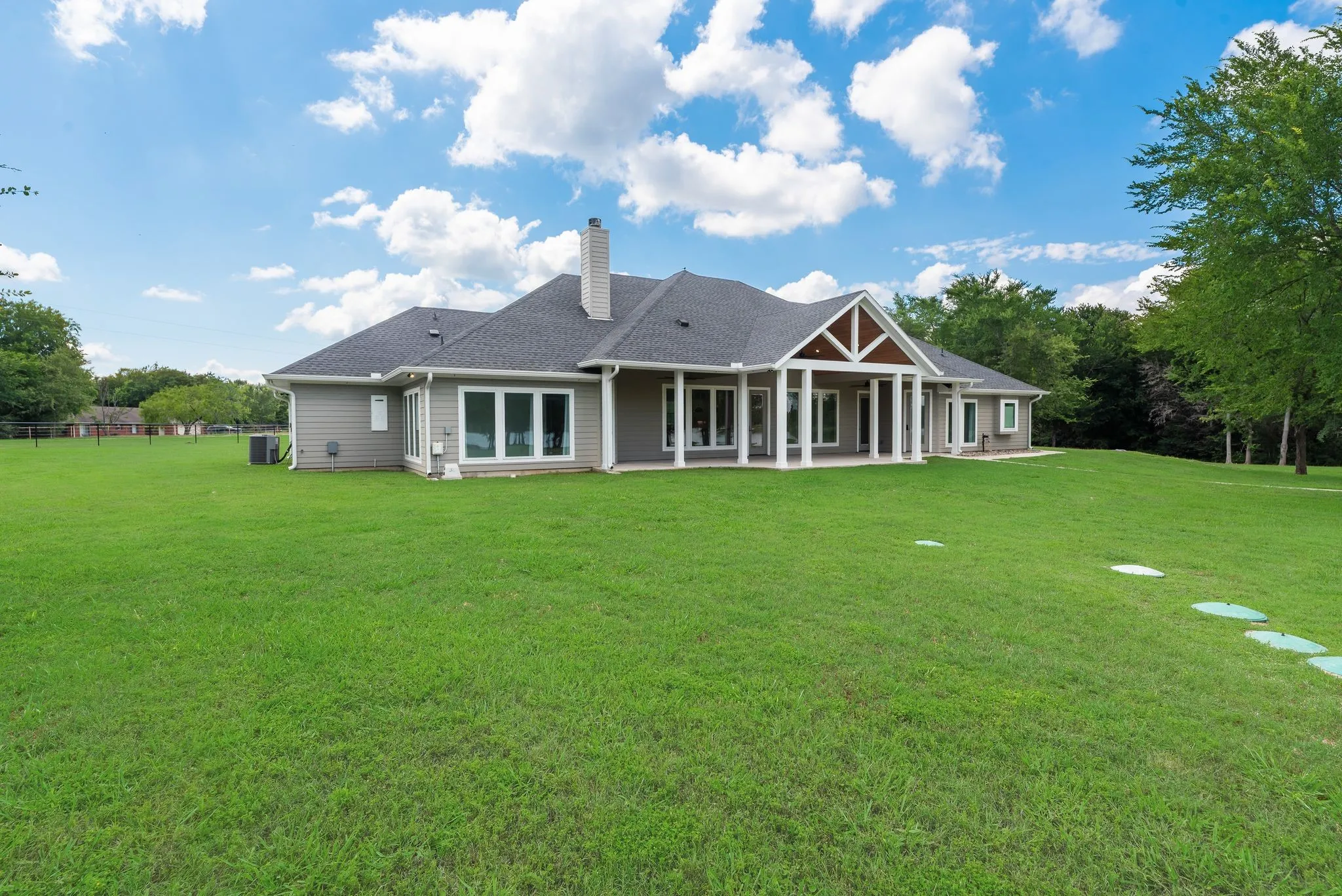 Rear exterior view of the custom lake home and spacious fenced yard.