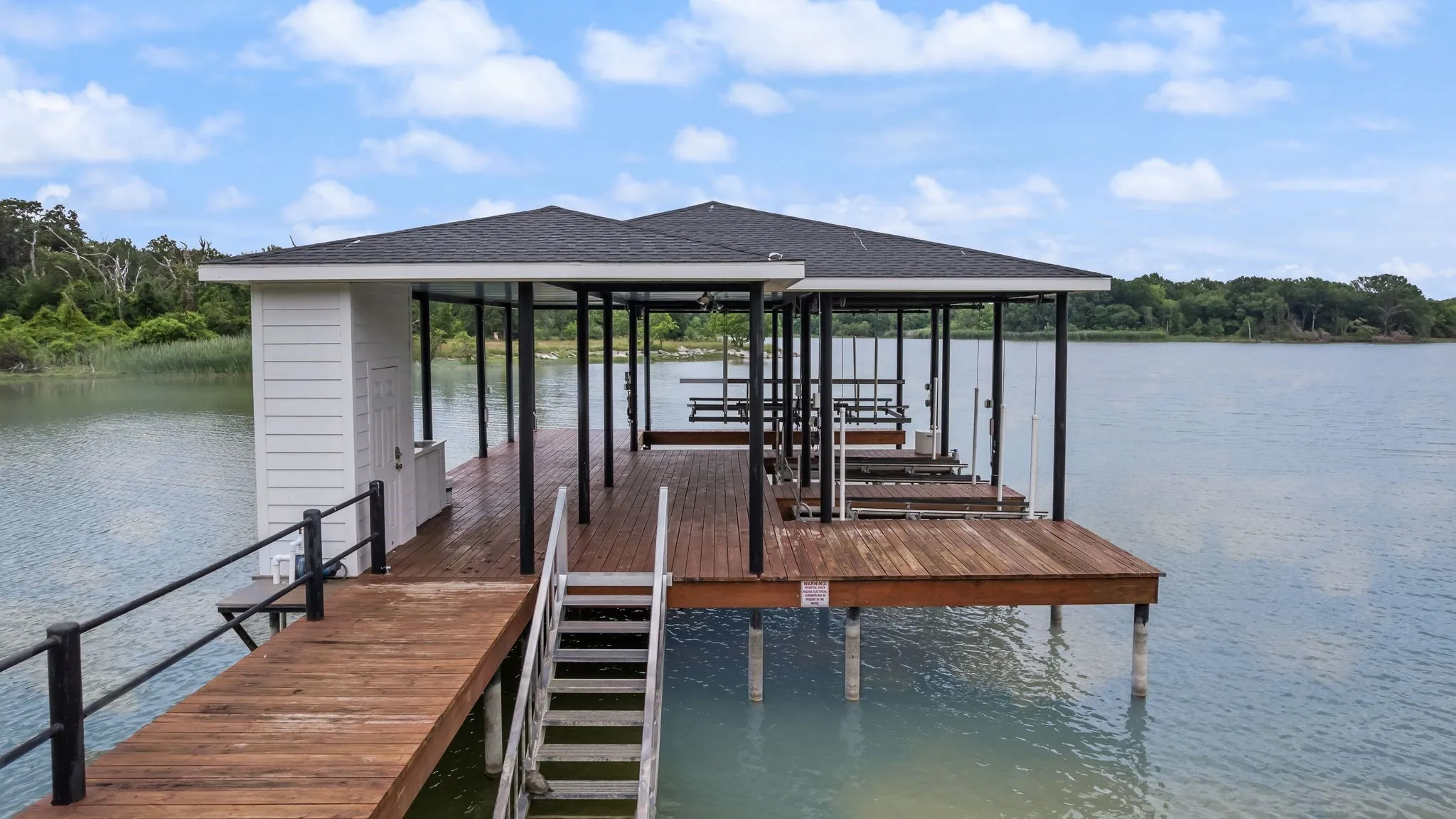 Covered dock with boat slip, jet ski lifts, storage, and lakefront entertaining space.