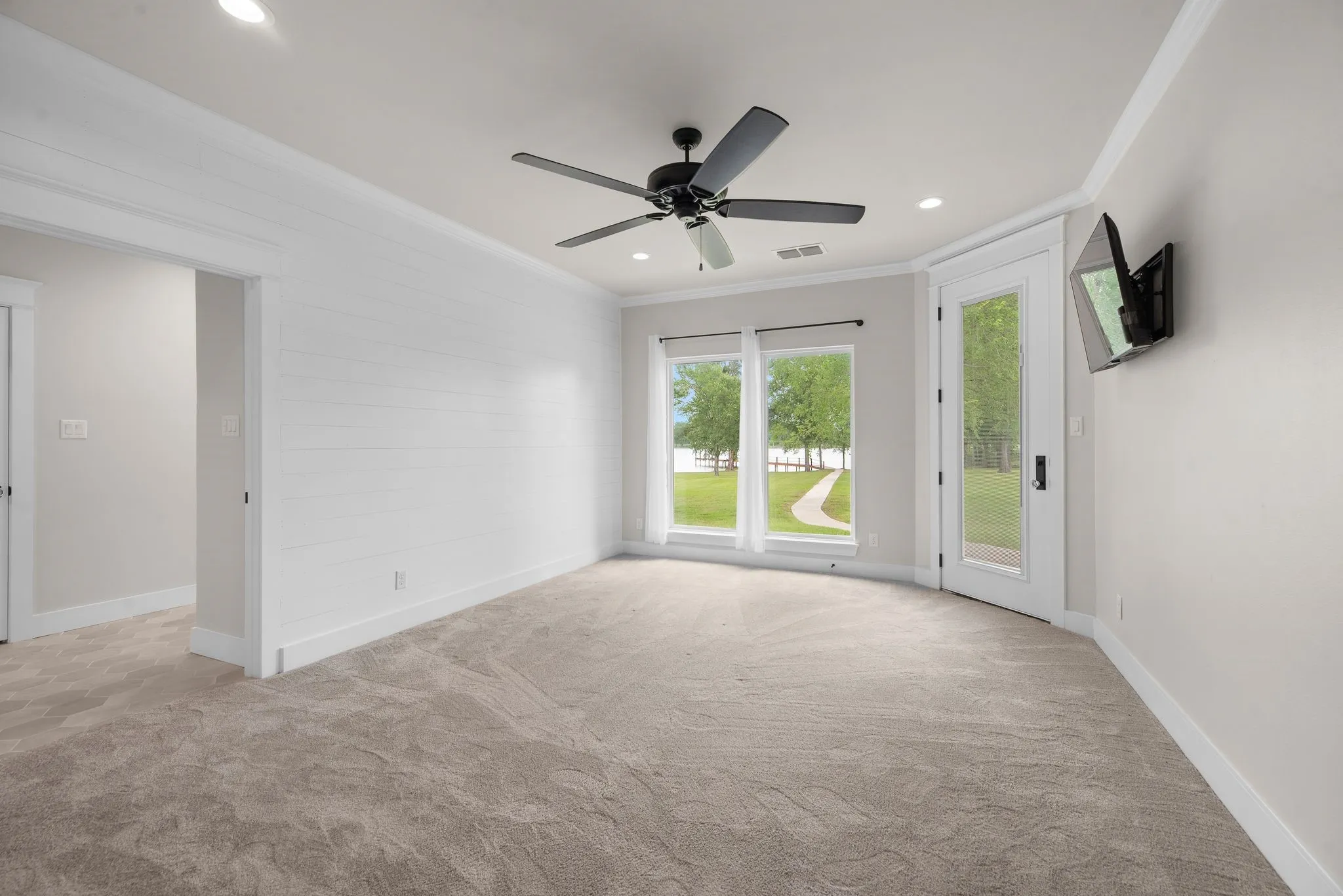 Second primary suite with soft carpet and private exterior access.