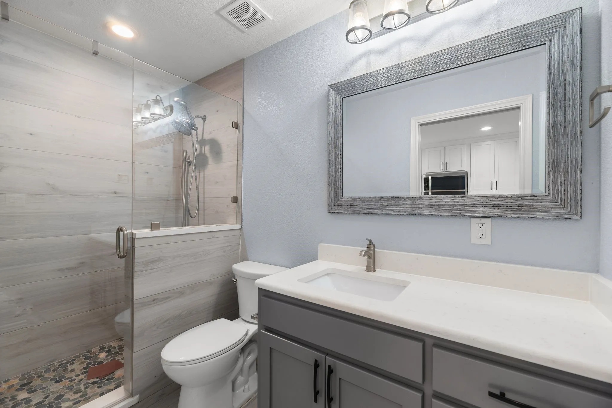 Guest apartment bathroom with walk-in shower and modern finishes.